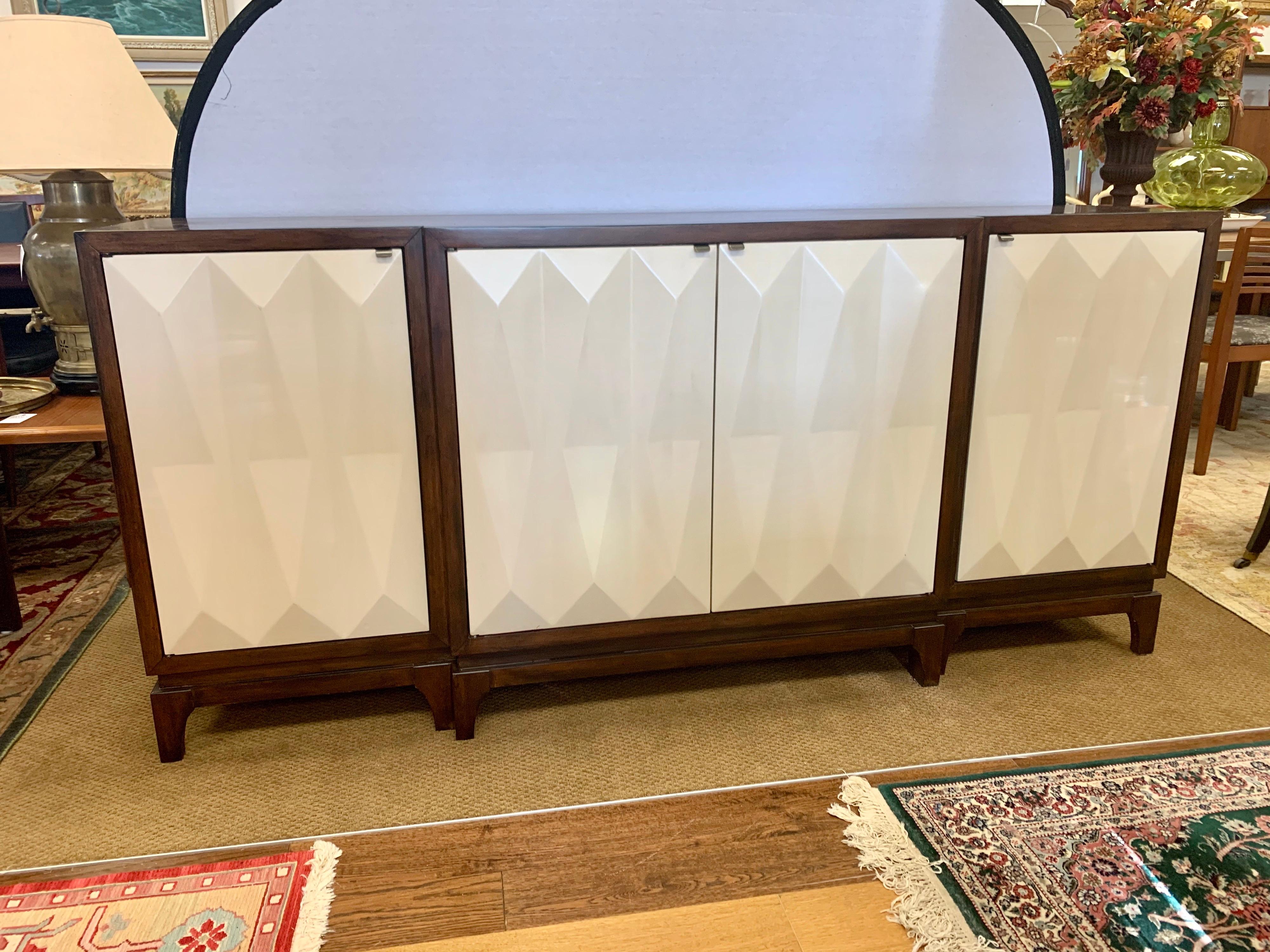 Elegant Hooker Furniture server with multiple storage options. What sets this piece apart is the off white
resin doors that have sculpted triangles formed onto the outer face of each door, circa early 21st century and in terrific condition.