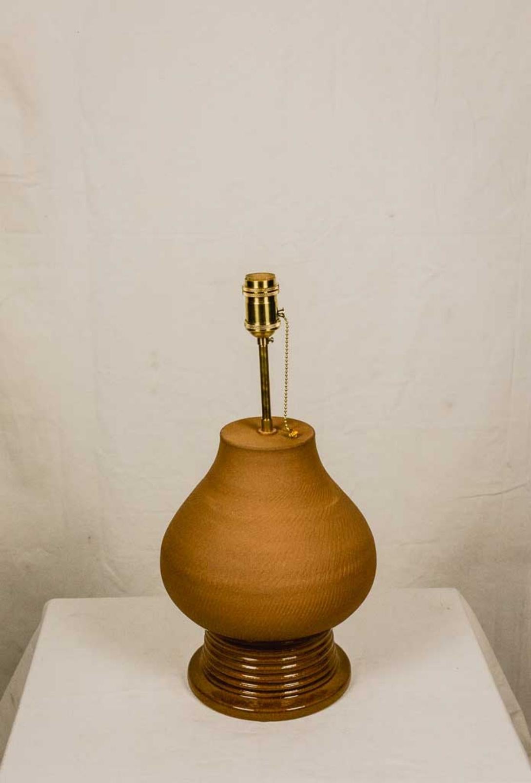 Table lamp inspired by the ancient amphora, which appears for the first time on the coasts of Lebanon and Syria, during the fifteenth century BC. C. and spread throughout the ancient world as easy to transport containers. The lamp is made of clay