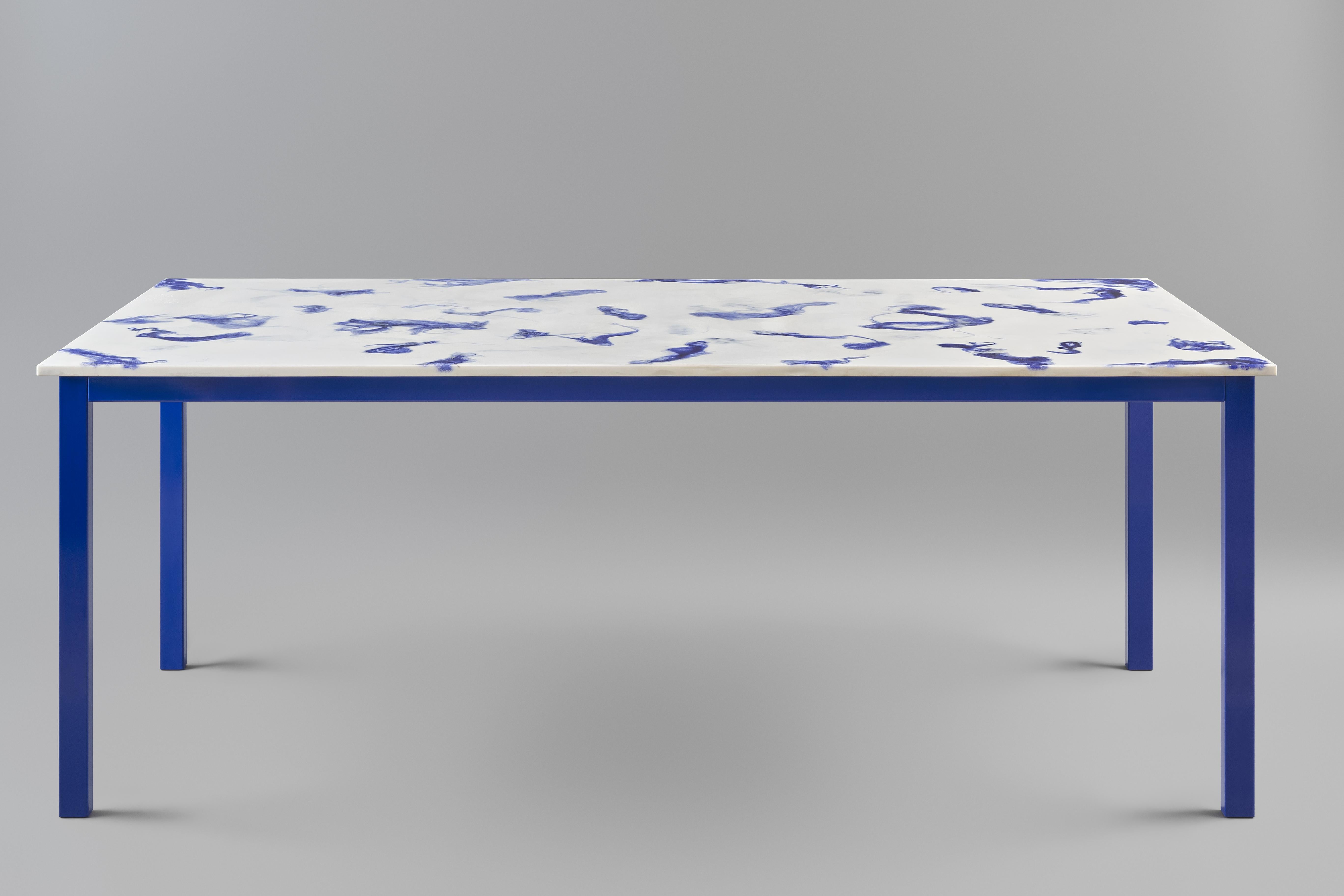 Fließender Esstisch.
Die Tischplatte ist aus Marwoolus-Material mit blauen Wollfasern und weißem Carrara-Marmor-Pulversockel gefertigt.
Die Stahlrahmenkonstruktion ist blau pulverbeschichtet.

Informationen zum Material:
Marwoolus ist ein
