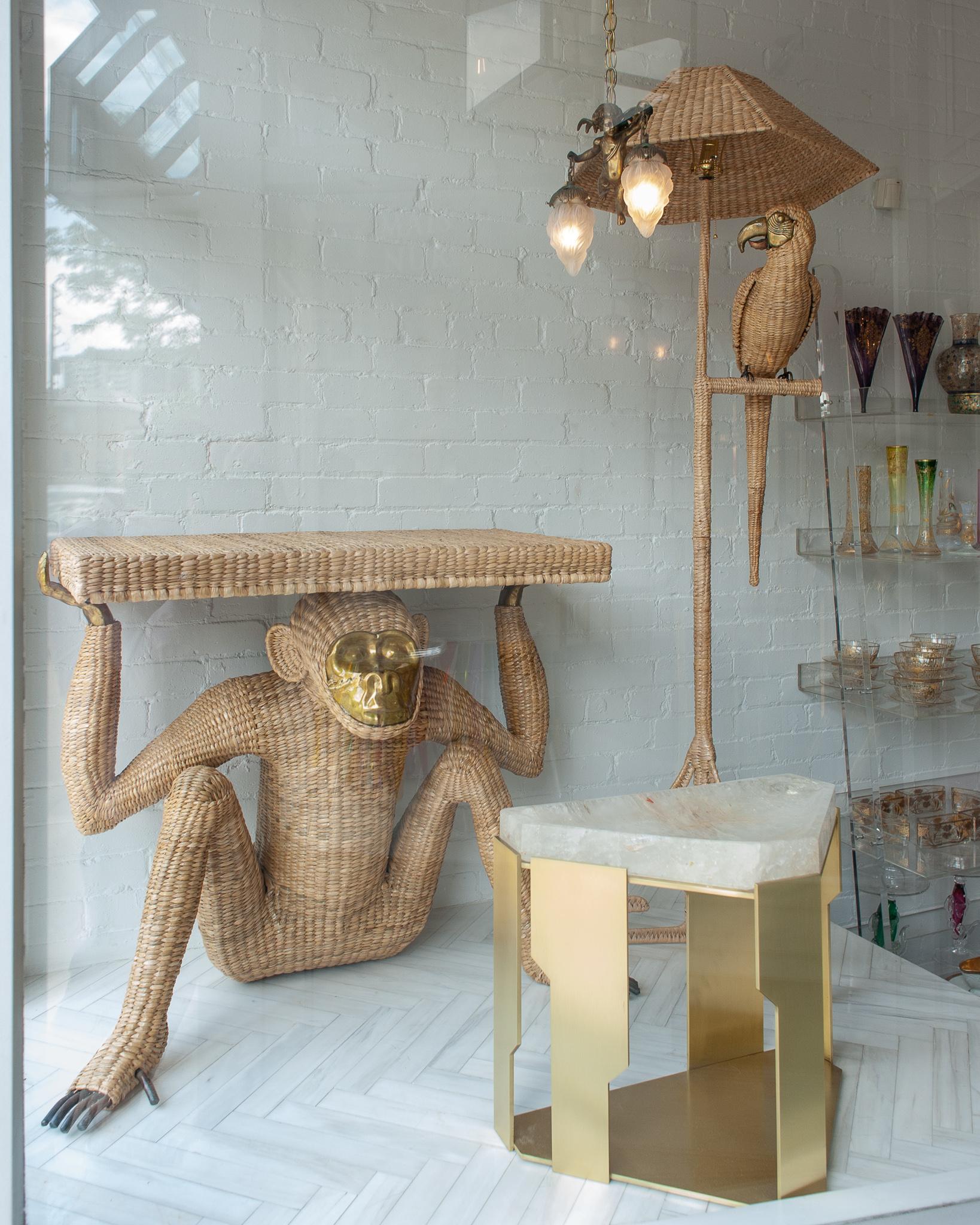 A stunning Mario Torres monkey console, constructed with a metal frame and expertly hand woven natural rattan. This console features a pressed brass face, fingers and exposed toes. Labeled with a brass medallion by Mario Lopez Torres Established