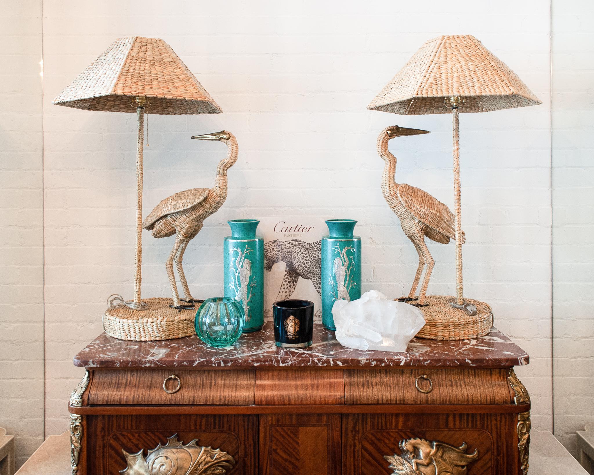 A contemporary pair of Mario Torres large crane table lamps, constructed with a metal frame and expertly hand woven natural rattan. Cranes feature pressed brass faces and beaks. Labeled with a brass medallion by Mario Lopez Torres Established 1974.