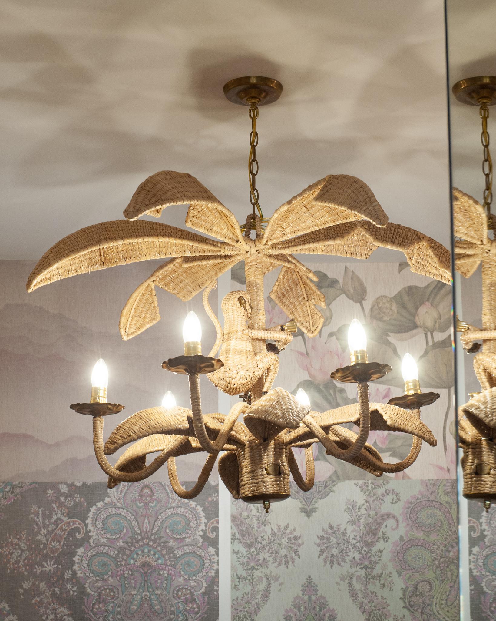 A whimsical Mario Lopez Torres monkey or Chimpanzee chandelier, constructed with a metal frame and expertly woven natural rattan. This chandelier features a single monkey with pressed brass face, fingers and exposed toes. Labeled with a brass