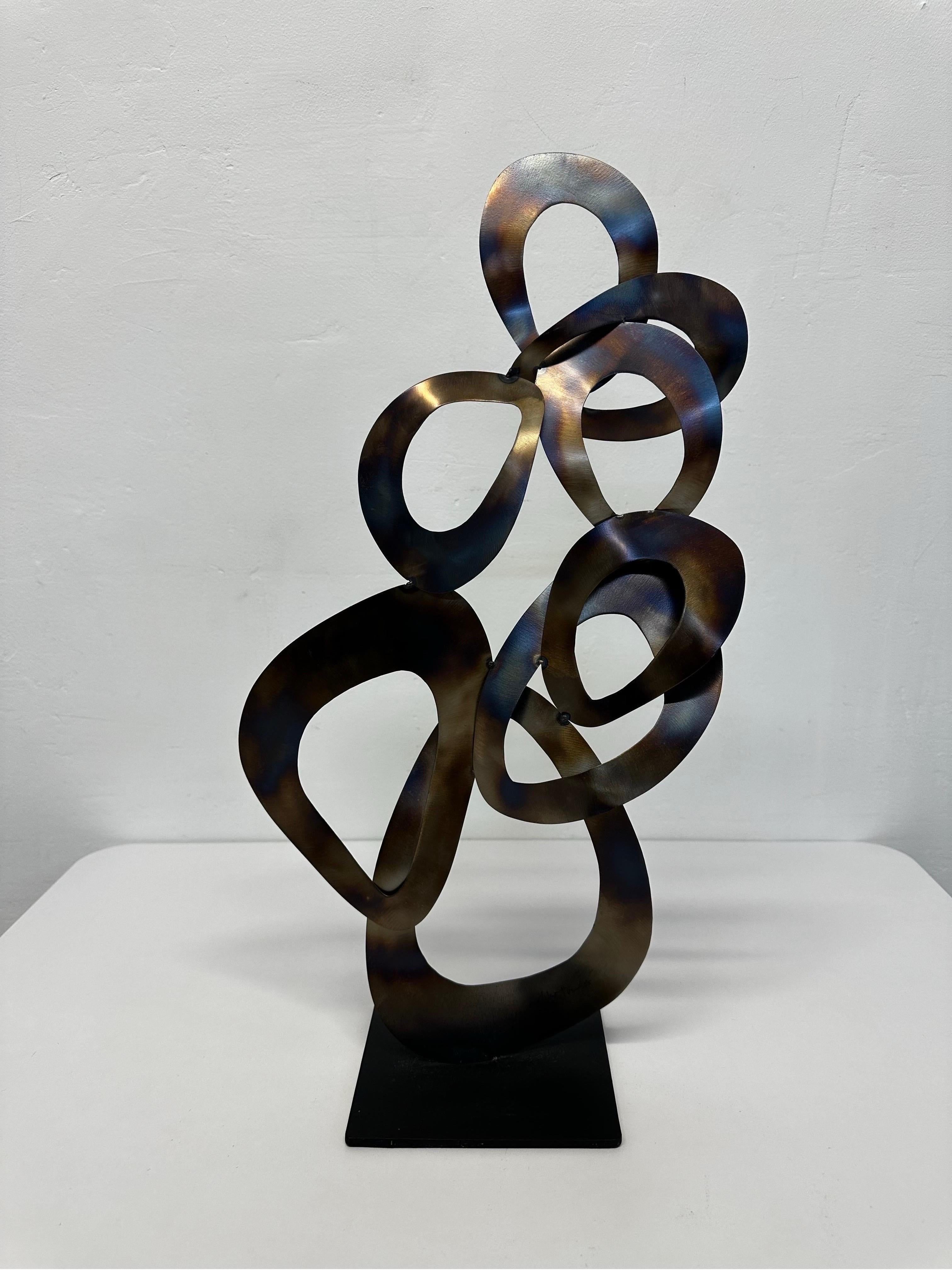Escultura contemporánea de metal sobre base de metal negro firmada por artista desconocido y fechada.