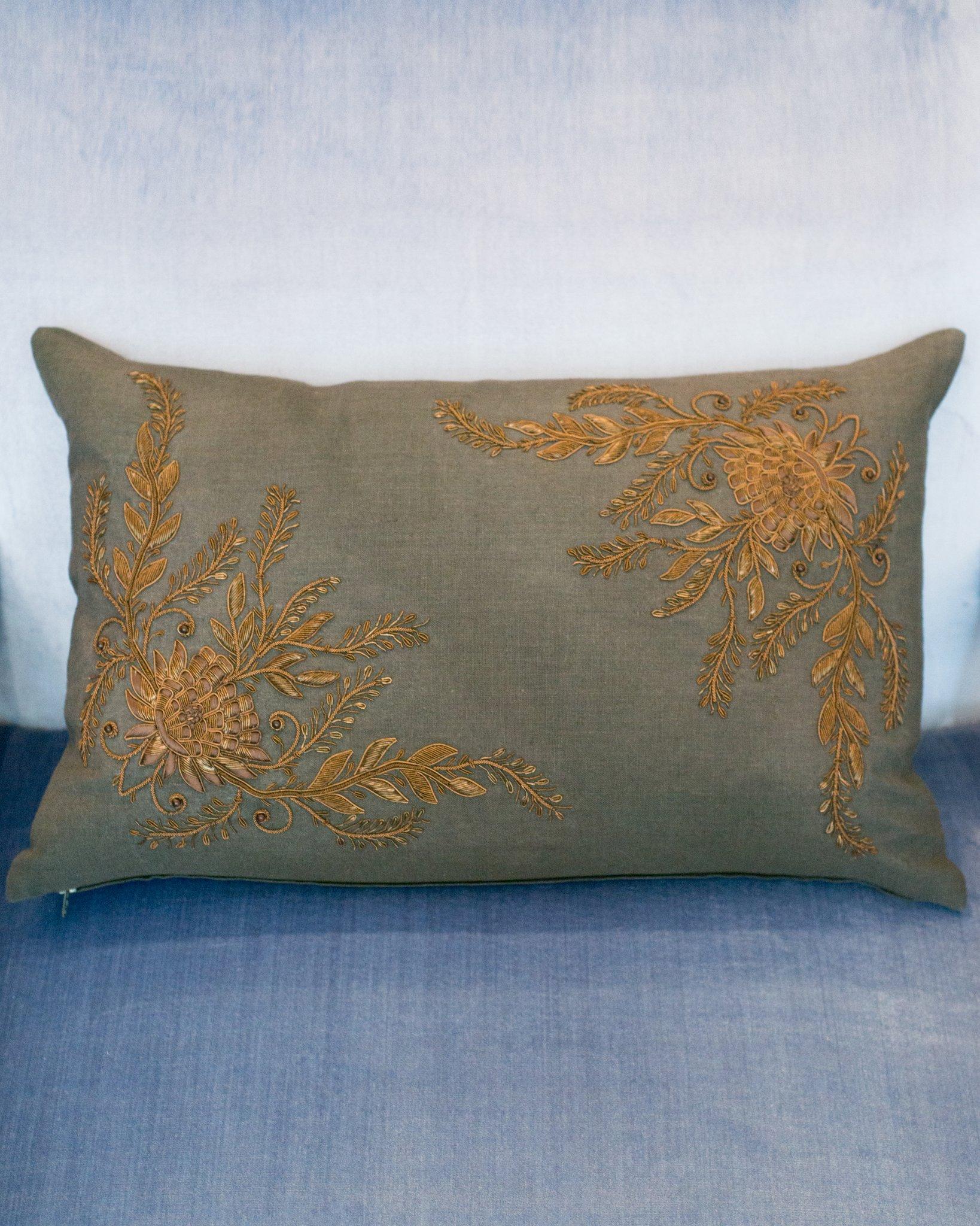 A charcoal linen pillow with metallic floral embroidery, down filled, made in India.
