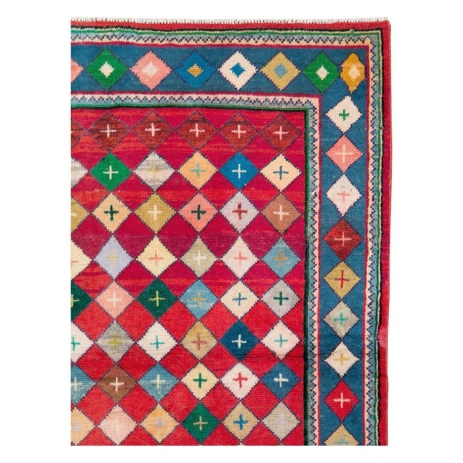 A vintage Persian Mahal throw rug handmade during the mid-20th century with a colorful and contemporary diamond lattice pattern over a red field. The diamond pattern extends into the cerulean blue border.

Measures: 3' 3
