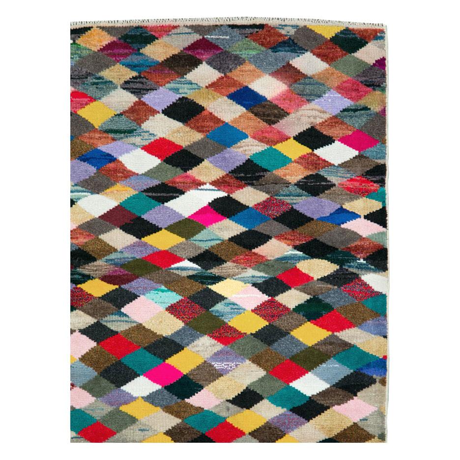 Un petit tapis d'accent vintage Persan Shiraz fait à la main au milieu du 20e siècle avec un motif contemporain et coloré en damier.

Mesures : 3' 1