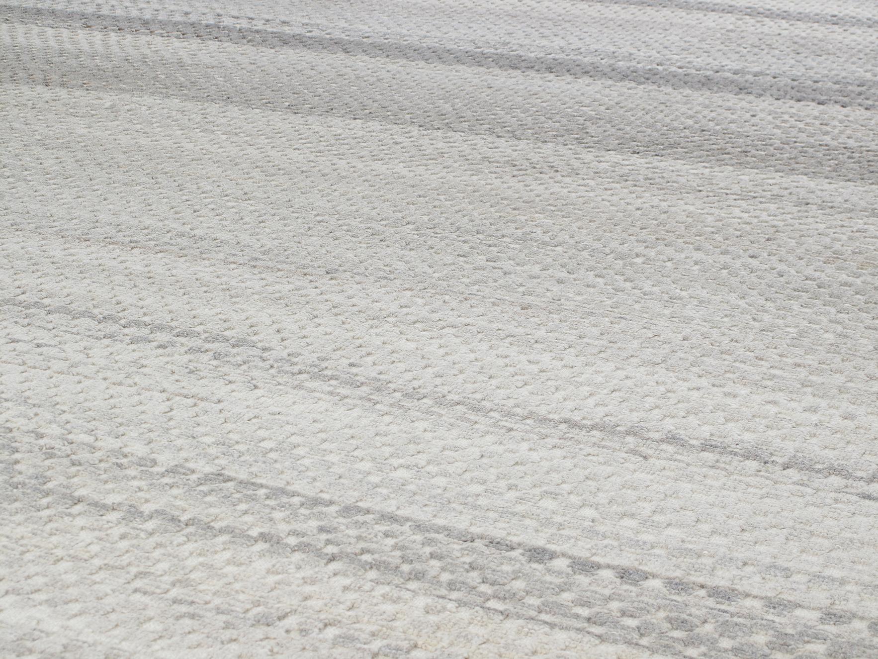 Esta alfombra anudada a mano está hecha de 100% lana y no está teñida en absoluto. Tiene un aire muy tribal y bohemio, pero al mismo tiempo es bastante neutro. El diseño en relieve de esta alfombra crea una gran cantidad de textura y dimensión