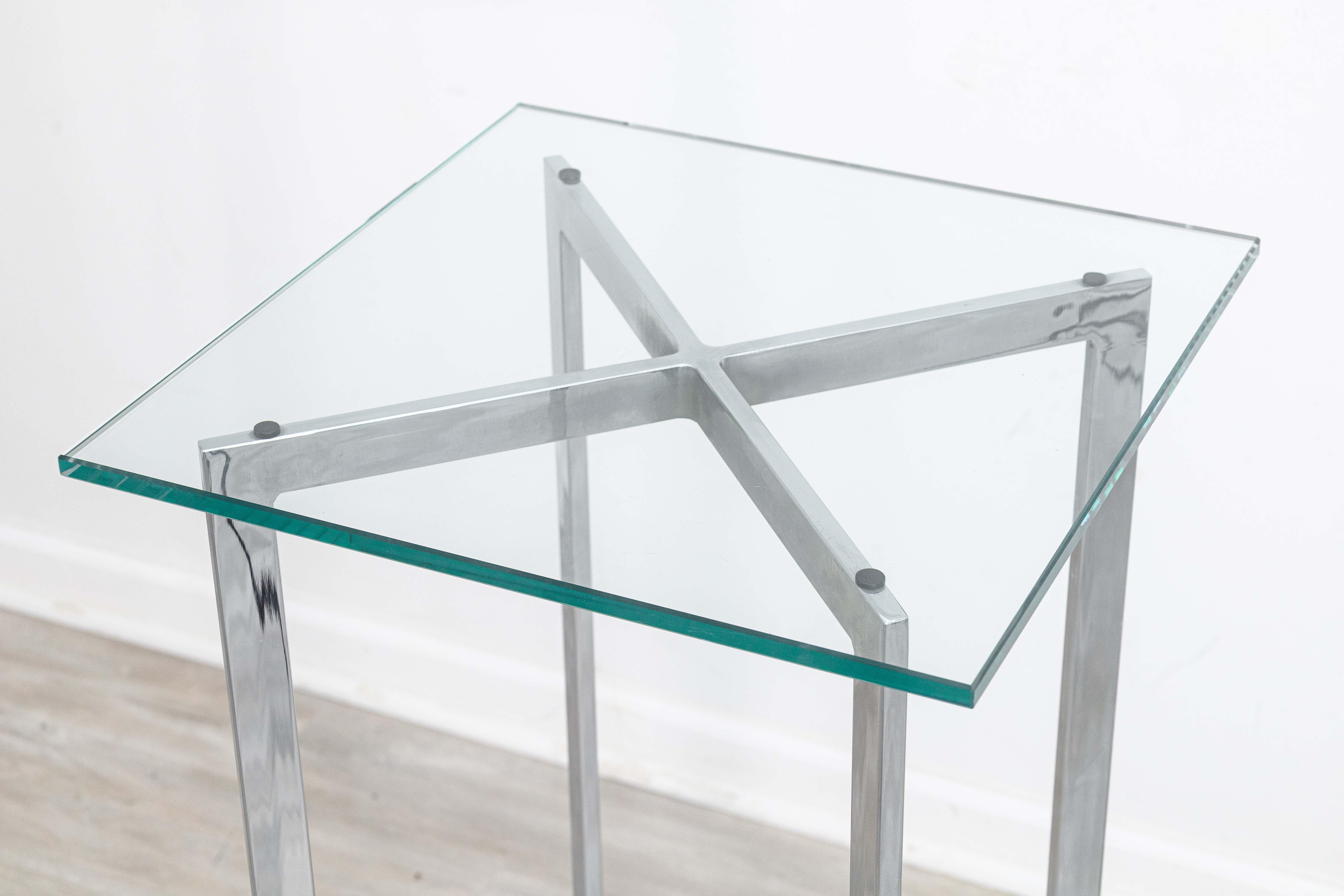 Un guéridon moderne et contemporain de style Mies Van Der Rohe Barcelona en chrome et verre. Ce piédestal moderne au design classique est doté de pieds et d'un cadre chromés à barre plate en forme de x. Le plateau de la table est un épais morceau de