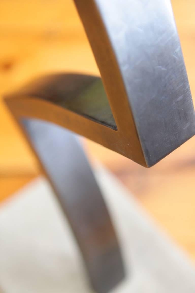 La Z-Table, un design original proposé exclusivement par Vermontica, est une table d'appoint contemporaine minimaliste en acier noirci et en verre moulé, conçue et produite dans le Vermont par Scott Gordon. Un piédestal angulaire et incurvé en acier