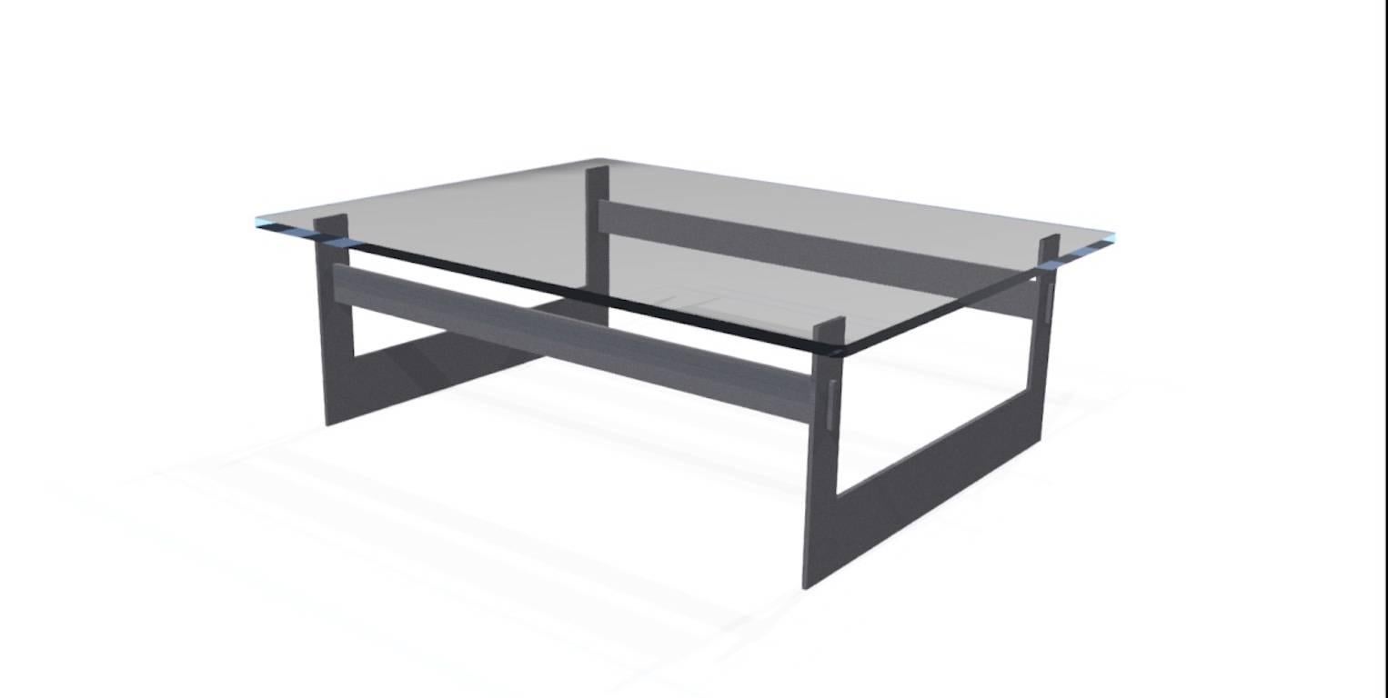 La table basse UMA, un design original proposé en exclusivité par Vermontica, est une table basse contemporaine minimaliste en acier noirci et en verre conçue et produite dans le Vermont par Scott Gordon. La base en acier de 3/8