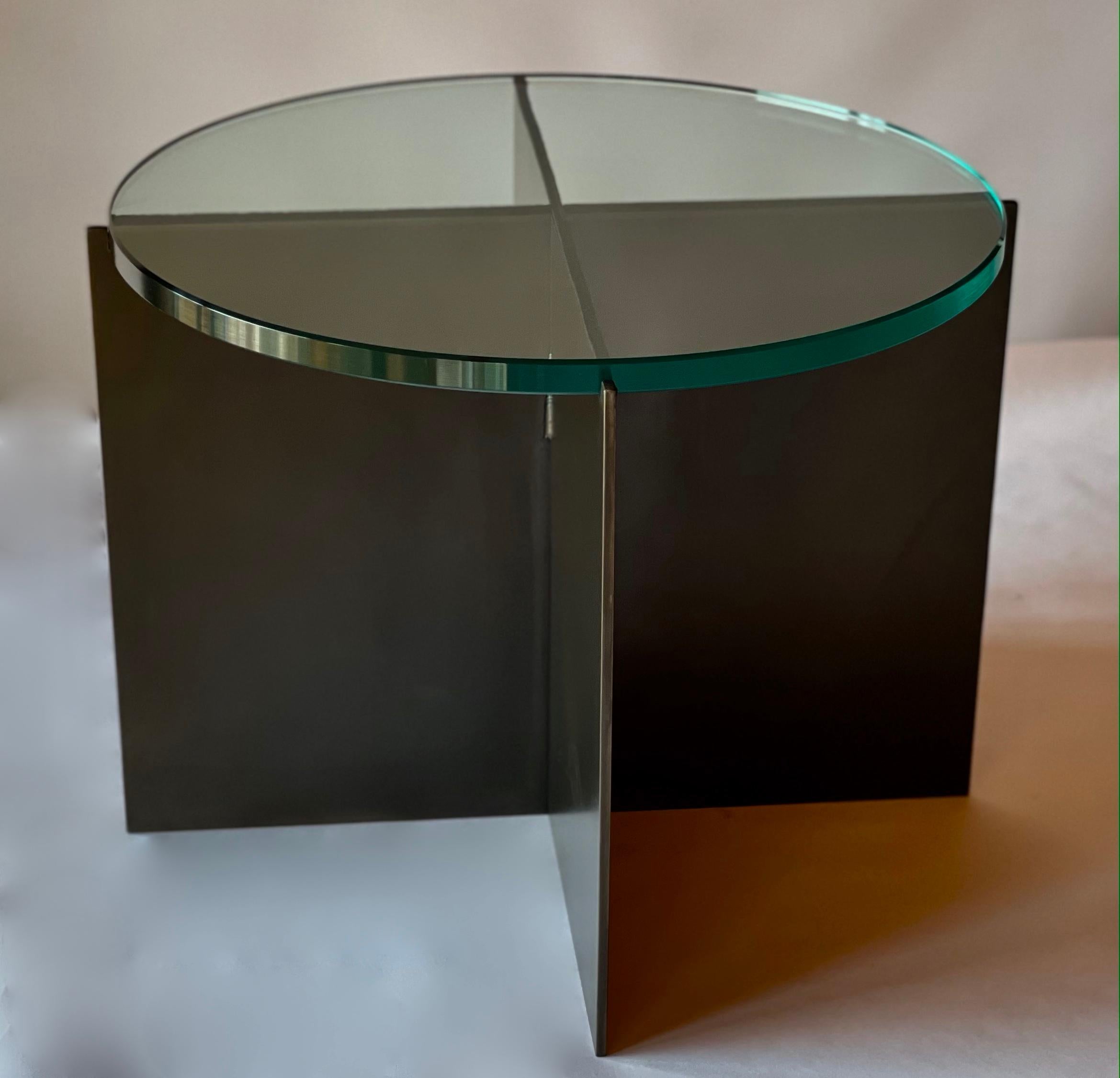 La Mesa Cocktail Crux, un diseño original ofrecido en exclusiva por Vermontica, es una mesa auxiliar minimalista contemporánea de acero ennegrecido y cristal diseñada y producida en Vermont por Scott Gordon. La base es de chapa de acero ennegrecido