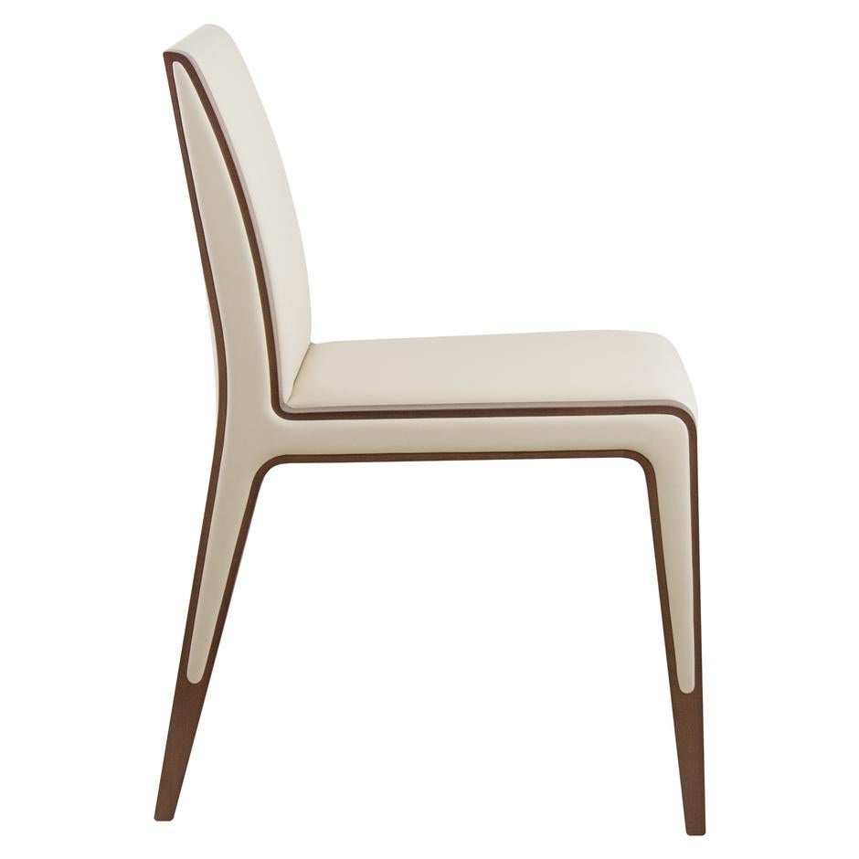 Modern dining chairs upholstered in beige faux leather. 
Crafted of solid wood frame stained in walnut finish. 
Slight reclined back help you stay comfortable and supported during long dinners.
This chair is heavily constructed and suitable for