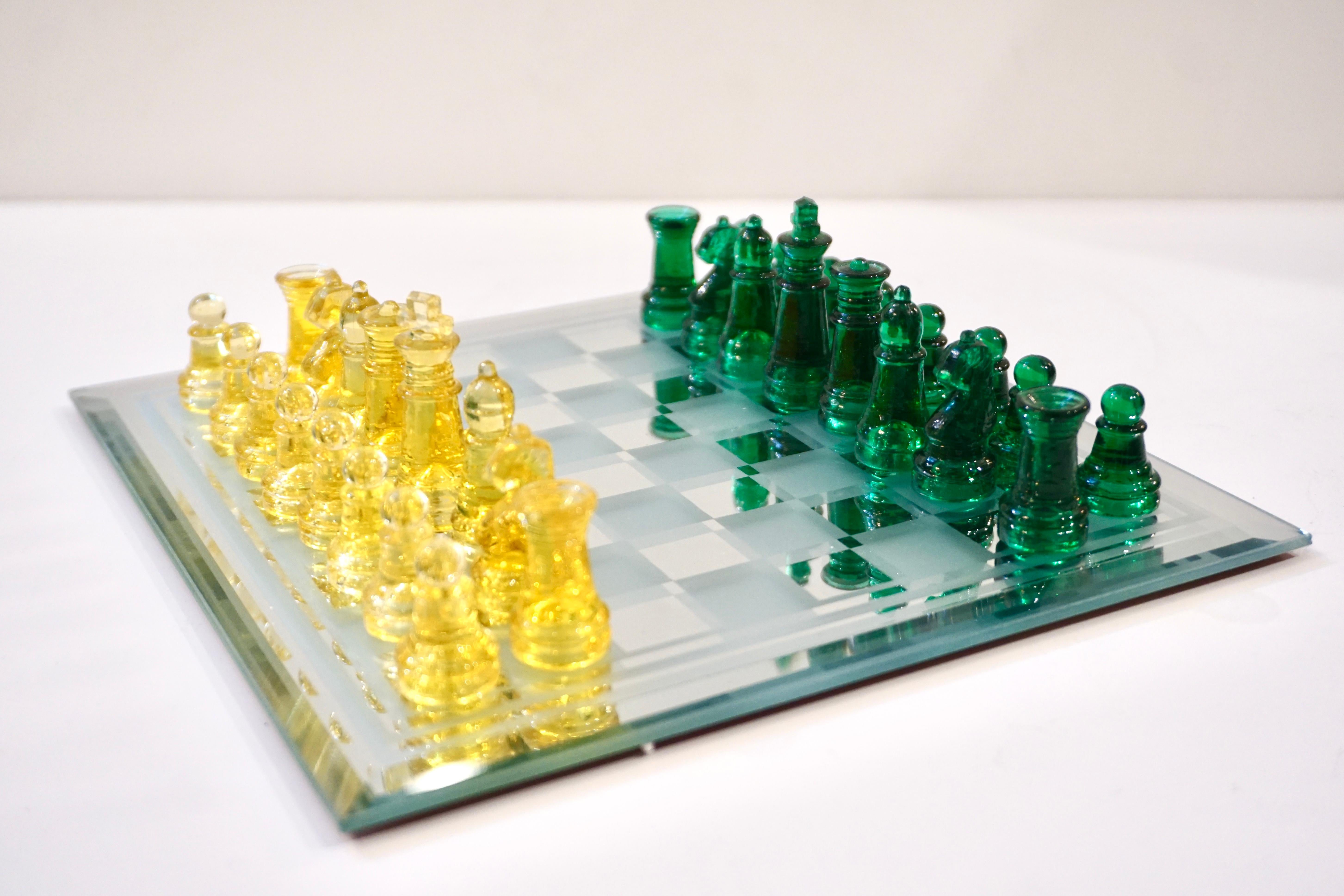 A fun Italian portable chess game of modern organic design, the detailed chess pieces are molded in vibrant green and yellow Murano Art glass, the mirror glass chessboard is decorated with frosted and mirrored squares, edged with a quality beveled