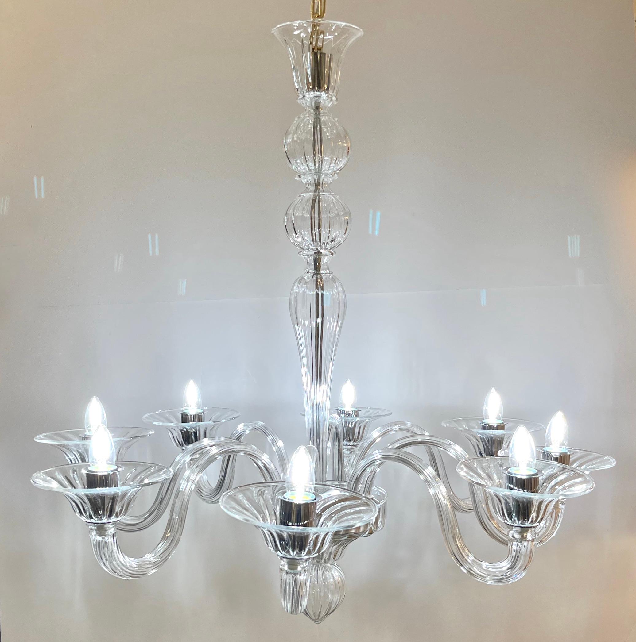 Minimalist modern creation of the traditional Venetian Chandelier, 8 lights, in artistic blown crystal Murano glass, entirely hand-crafted in Italy.
This lighting fixture in Murano glass is characterized by superb sinuous simplicity. It is inspired