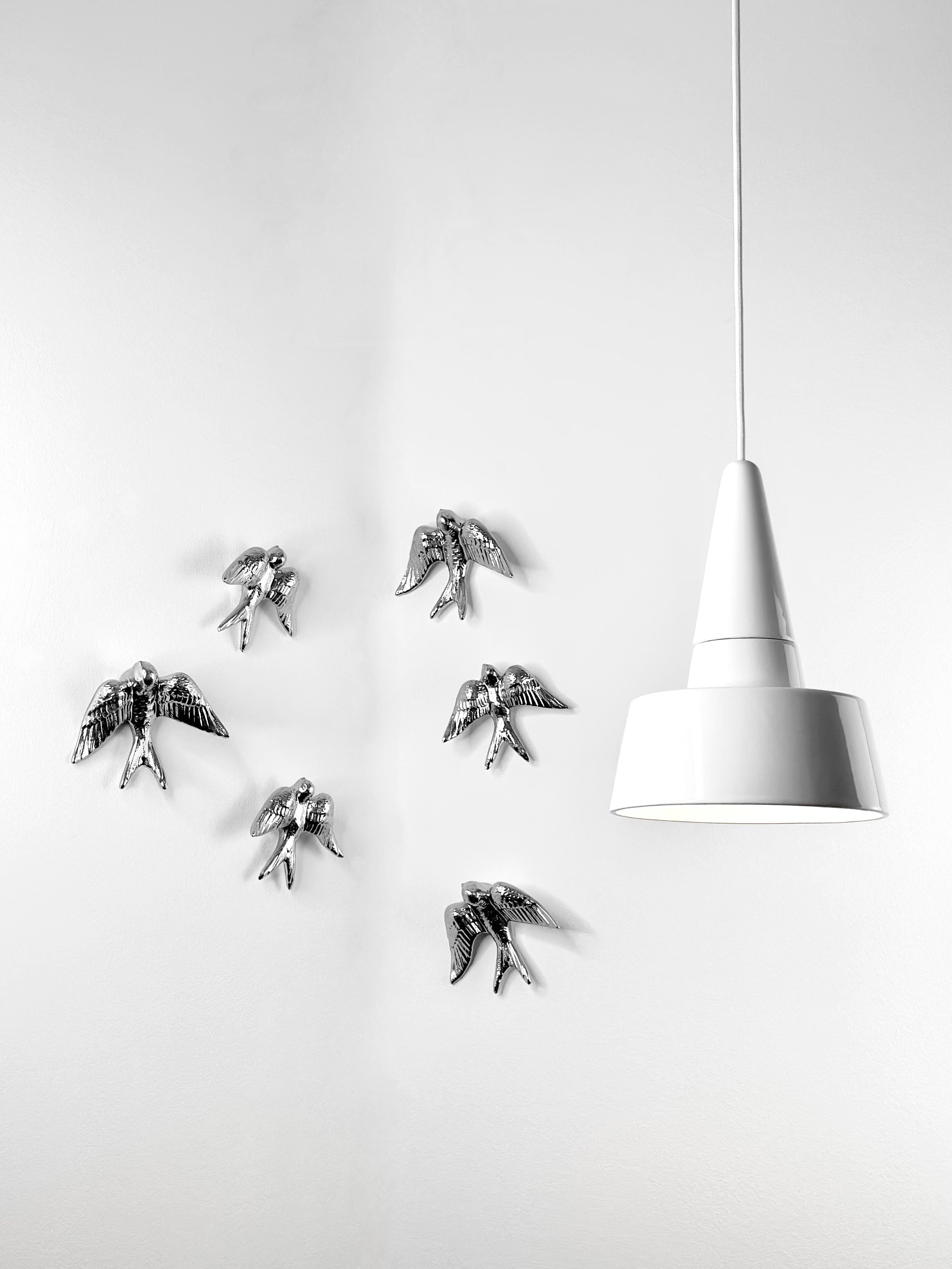 SWALLOWS Wall Ornament
Designed by Rodrigo Vairinhos

The SWALLOWS wall ornament set is a truly artistic and symbolic addition to any home. This unique set of 6 ceramic swallows—three measuring 13 cm and three at 14.5 cm—brings both elegance and