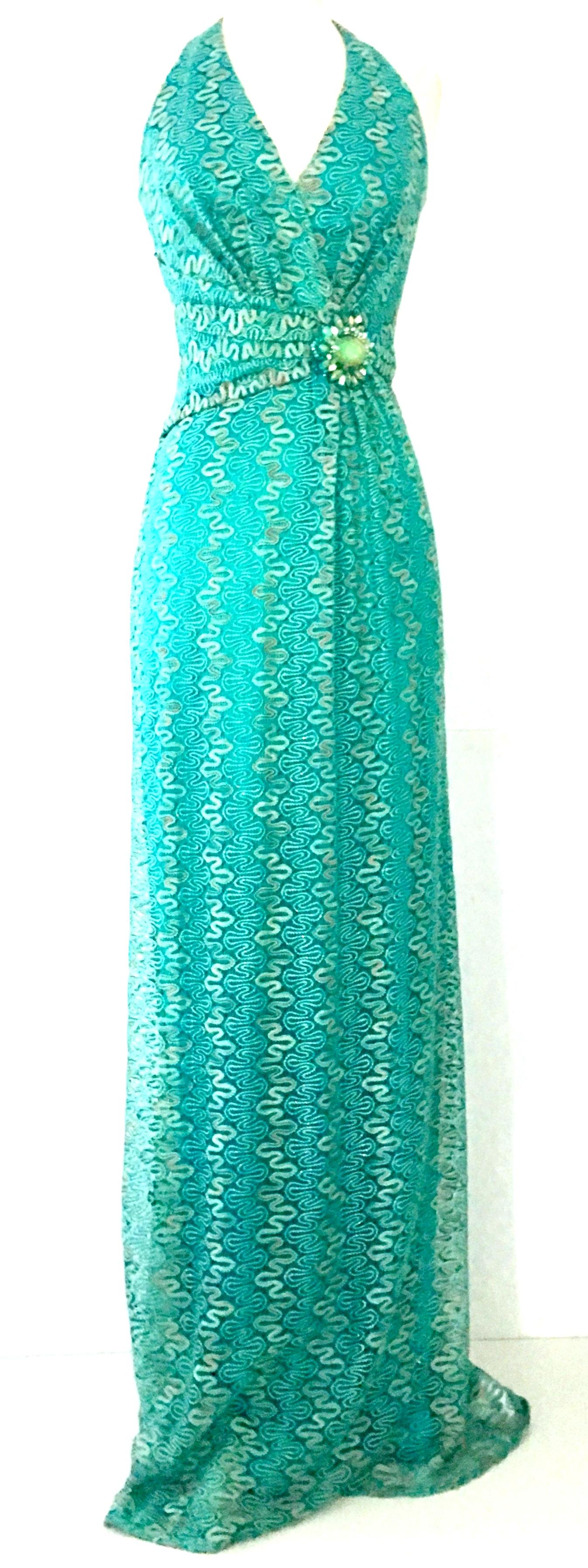 Contemporary & New With Tags, Missoni Style Maxi Halter Dress By, David Meister. Features a teal knit ground with silver metallic threading detail. The faux belt at the waist features a large 