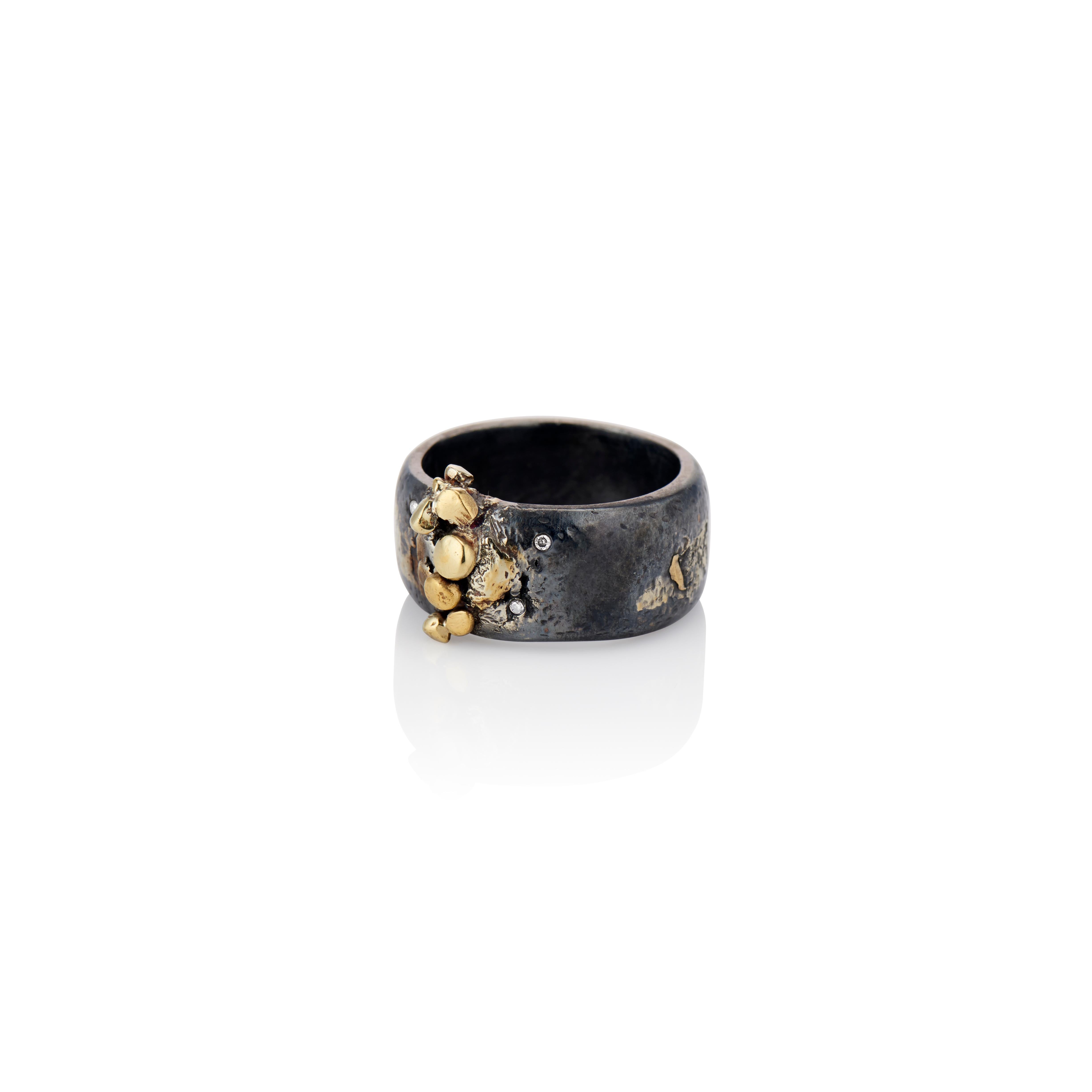 This beautifully textured, 22 karat yellow gold and oxidized Sterling silver band ring makes a unique statement.  Hand wrought from the metal, it is gently curved with 22 karat yellow gold sculpted 