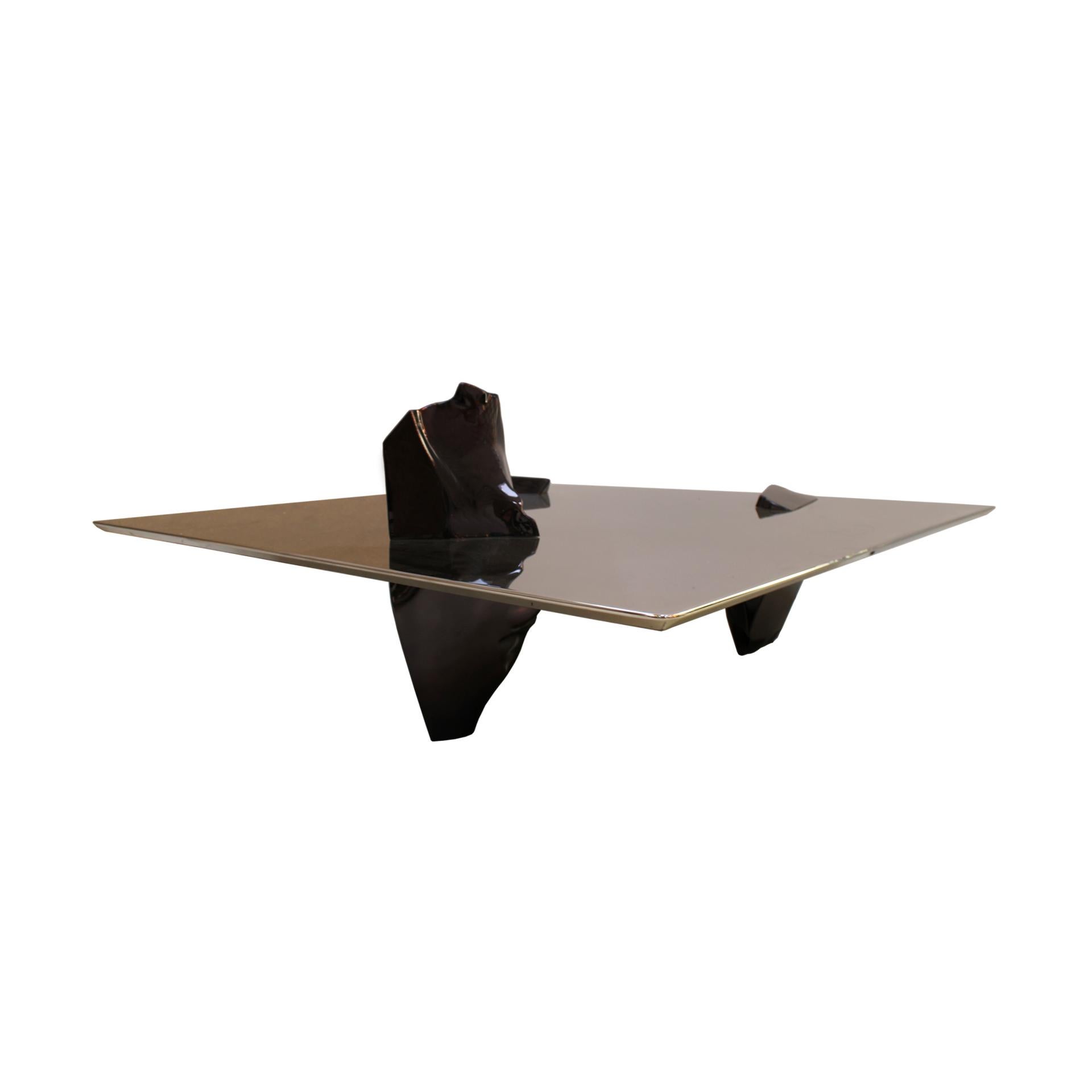 Sereno model coffee table designed by Fredrikson Stallard for Driade. Structure formed by three sculptural pieces in cast aluminum finished in black titanium. Top made of wood covered in thick mirror polished stainless steel sheet. Italy 21st