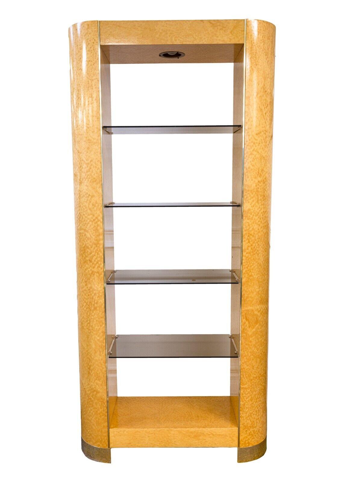 A birdseye maple etagere with smoked glass. This wonderful piece of furniture is a great showcase piece. This etagere features a beautiful birdseye maple construction with brass detailing on the sides and the legs, and super sleek, clean smoked