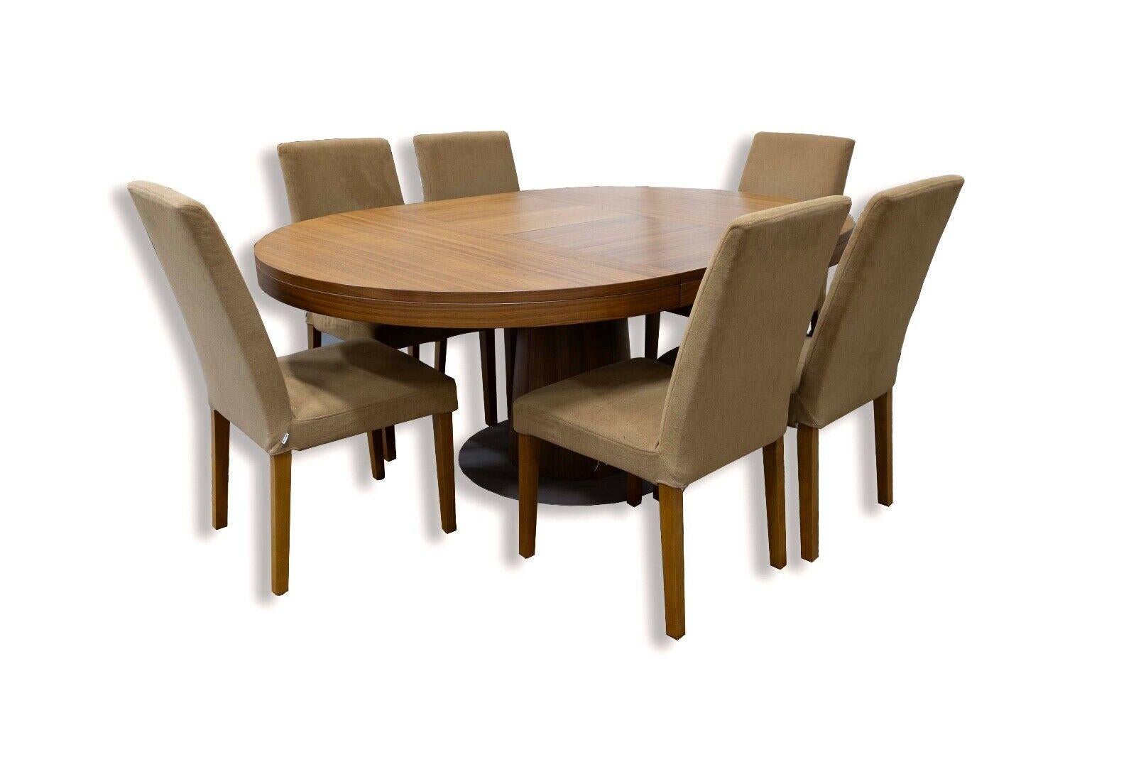 The BoConcepts Granada Model Expandable Dining Table and 6 Chairs embody contemporary elegance and versatility in dining furniture. The walnut wood table features a sleek, minimalist design with a beautifully finished tabletop that extends to