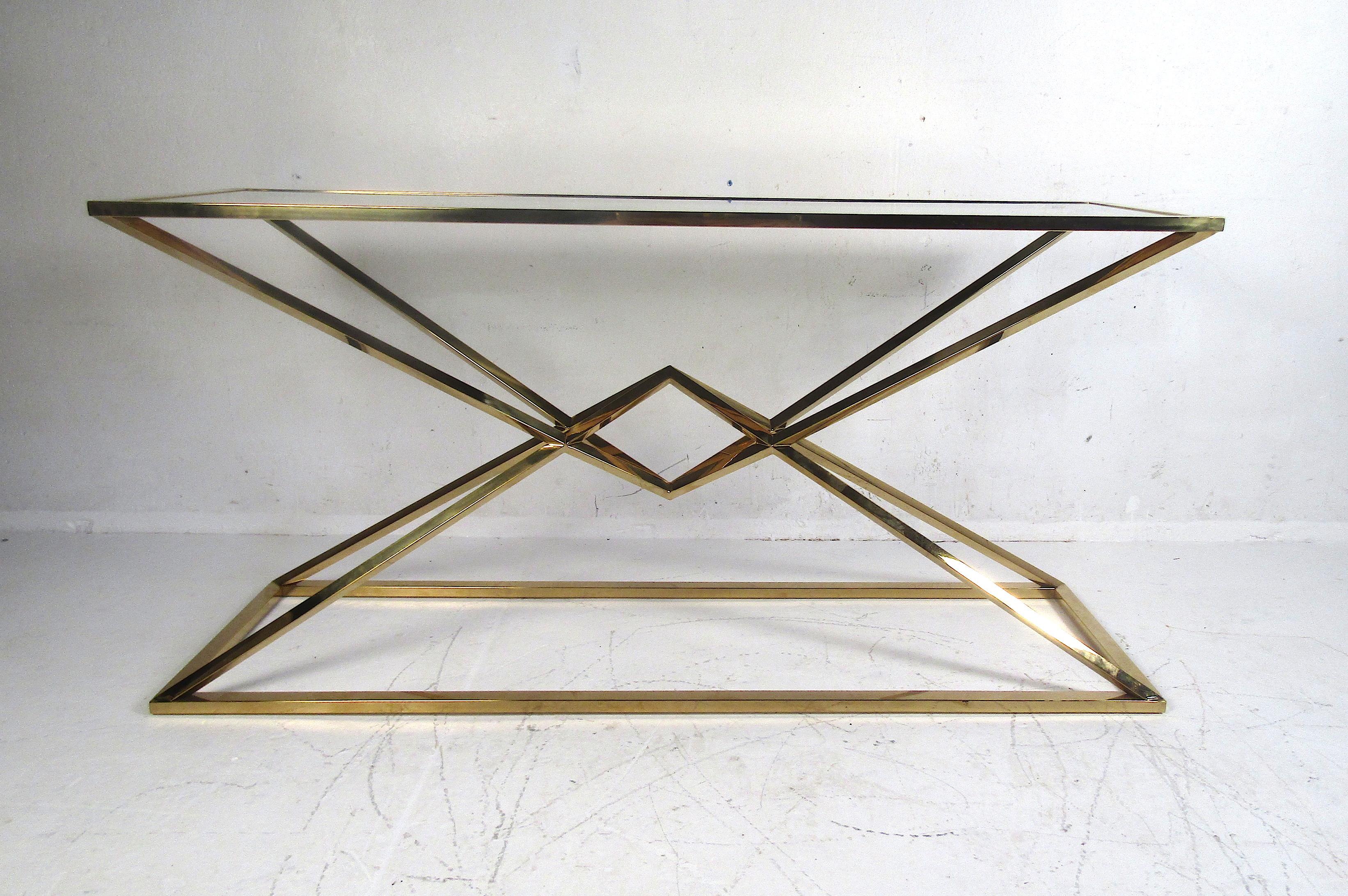 Impressive modern console table with a brass frame and glass insert serving as the tabletop. Interesting design with good metalwork. Sturdy piece with quite a bit of weight to it. This console/hallway table would make a notable addition to any