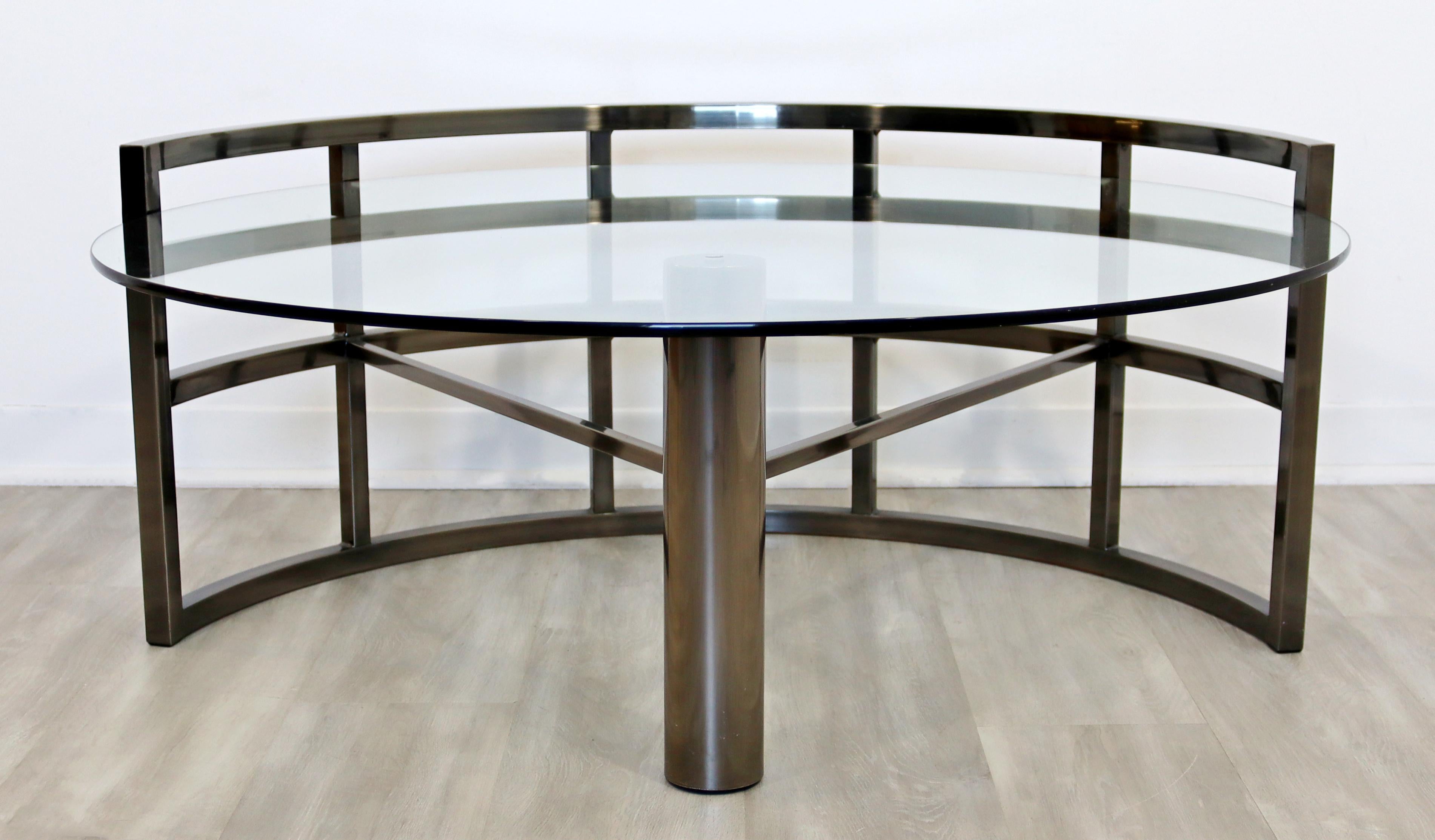 For your consideration is an outstanding, asymmetrical coffee table, with a glass top in a gunmetal base, circa the 1980s, in the style of Brueton. In excellent vintage condition. The dimensions are 42