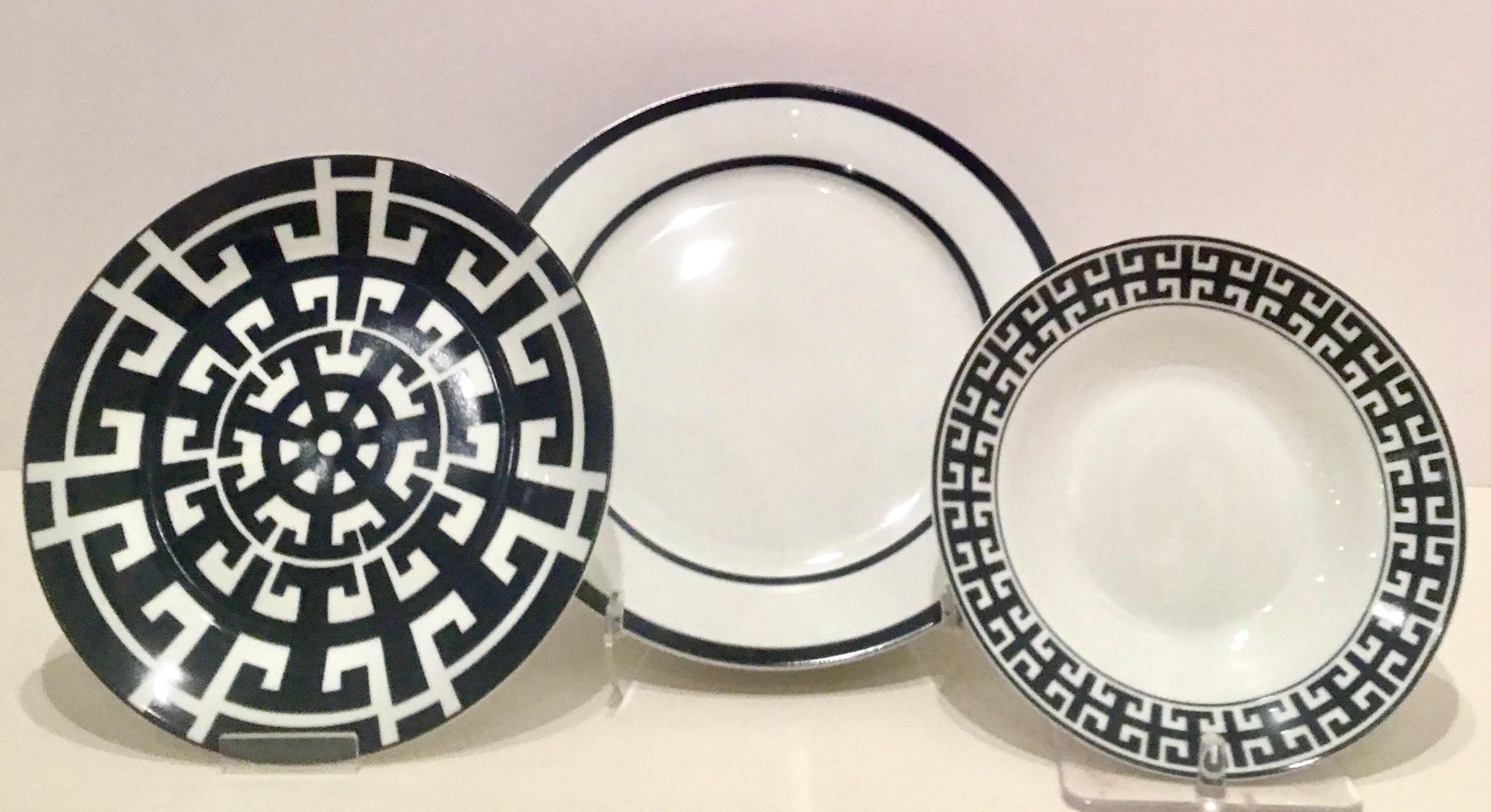 21st Century Contemporary & Modern, new geometric ceramic dinnerware set of 23 pieces by, Colin Cowie. Set features a bright white ground with navy blue pattern detail. Set includes, eight dinner plates, eight salad/dessert plate and seven coupe
