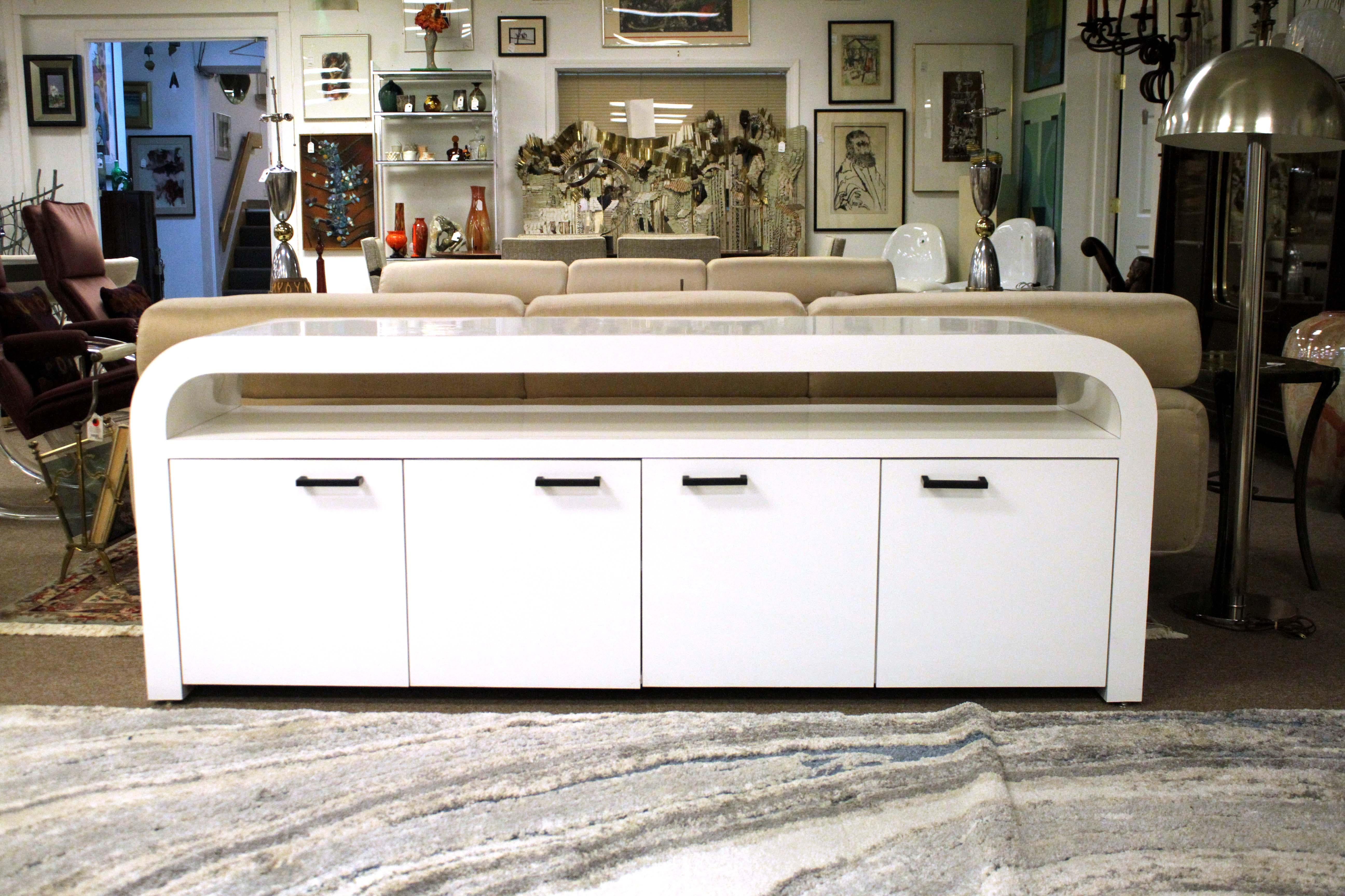 This contemporary custom made curved white lacquer credenza is a stunning piece of furniture that will be the centerpiece of any room. Its unique curved design gives it an unmistakable modern style that will fit perfectly in any modern home. The