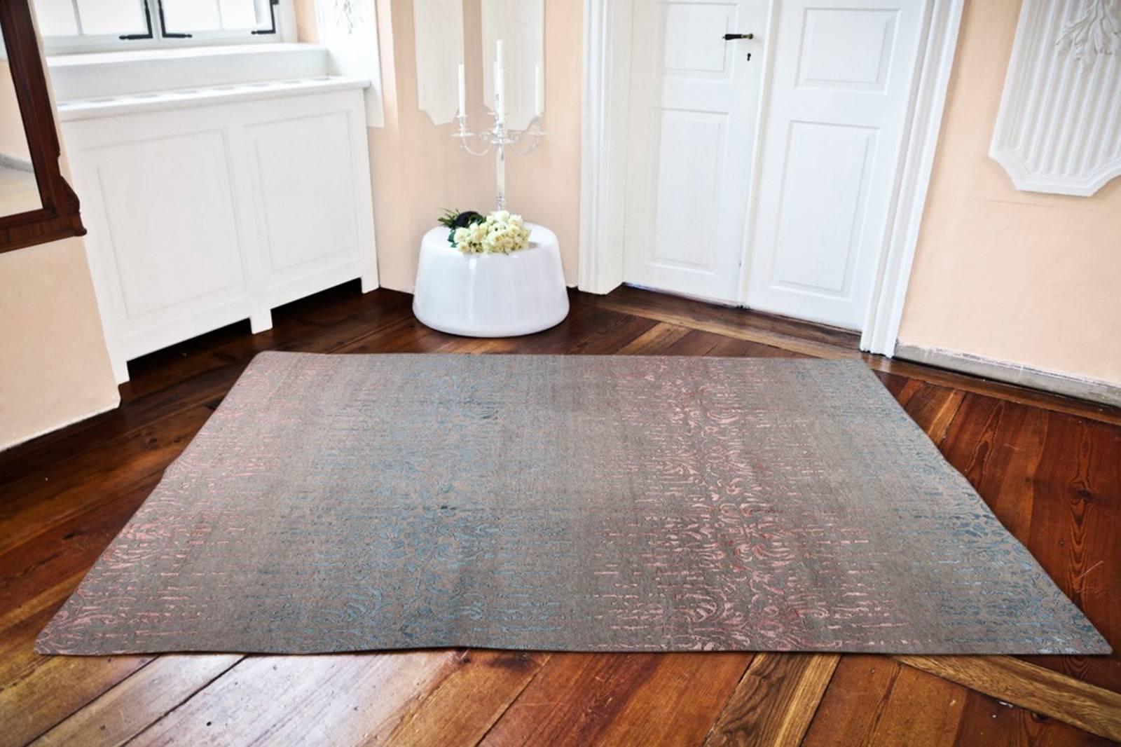 A beautiful hand-knotted oriental rug with contemporary modern design. This grey, blue and rose colored rug is astonishing because of its elegant reduced design. On the grey background color, the motives shine out. It flows between warm and cool