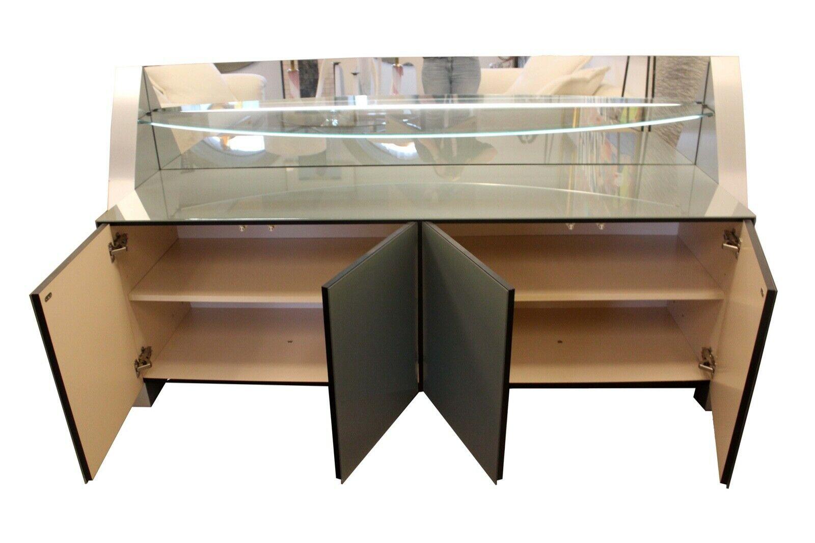 Contemporary Modern Ello curved credenza that also lights up for beautiful display. In great condition. Dimensions: 80 W x 22.5 D x 42.5 H.
 