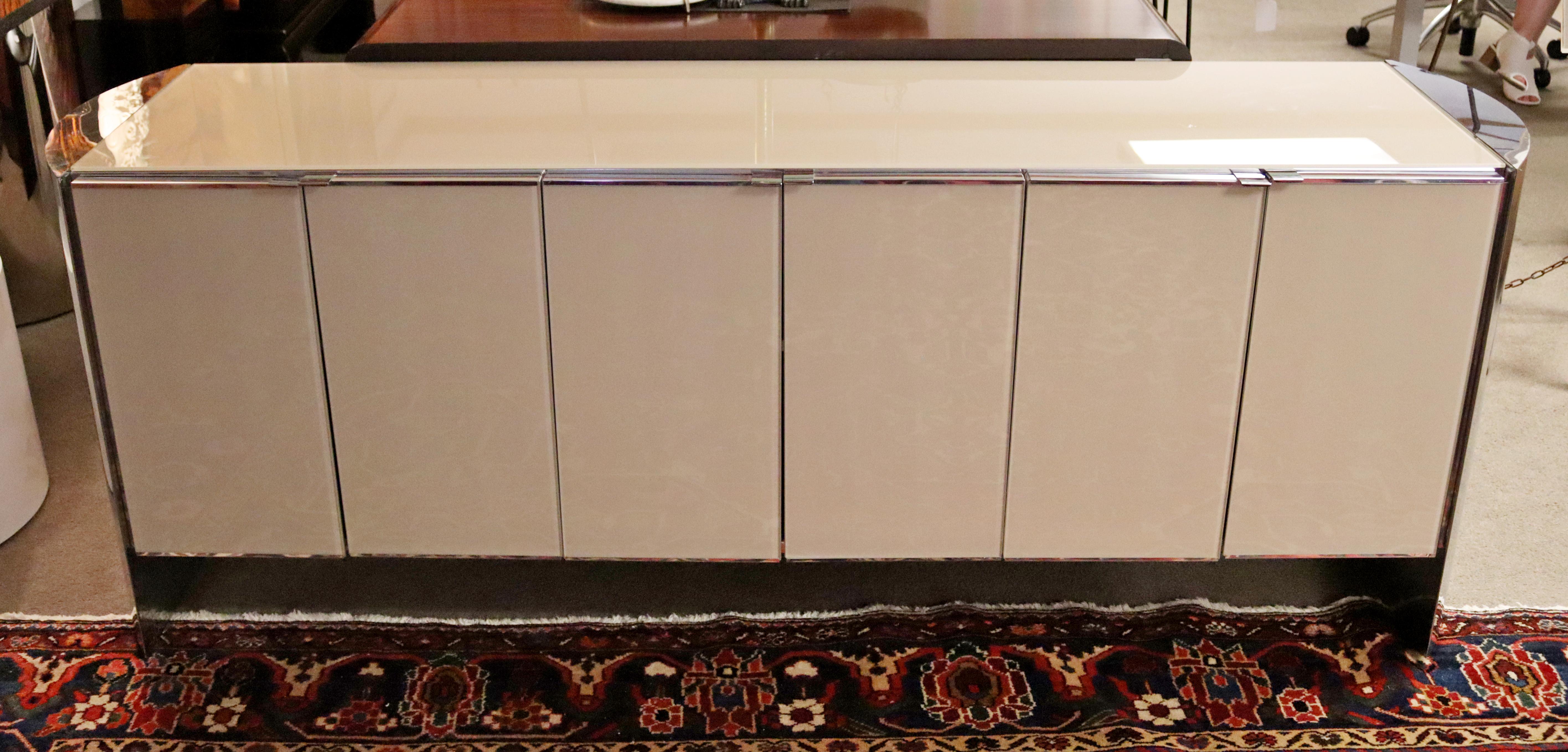 For your consideration is a gorgeous, mirrored chrome credenza, with pink glass doors, by Ello, circa the 1980s. In excellent vintage condition. The dimensions are 80