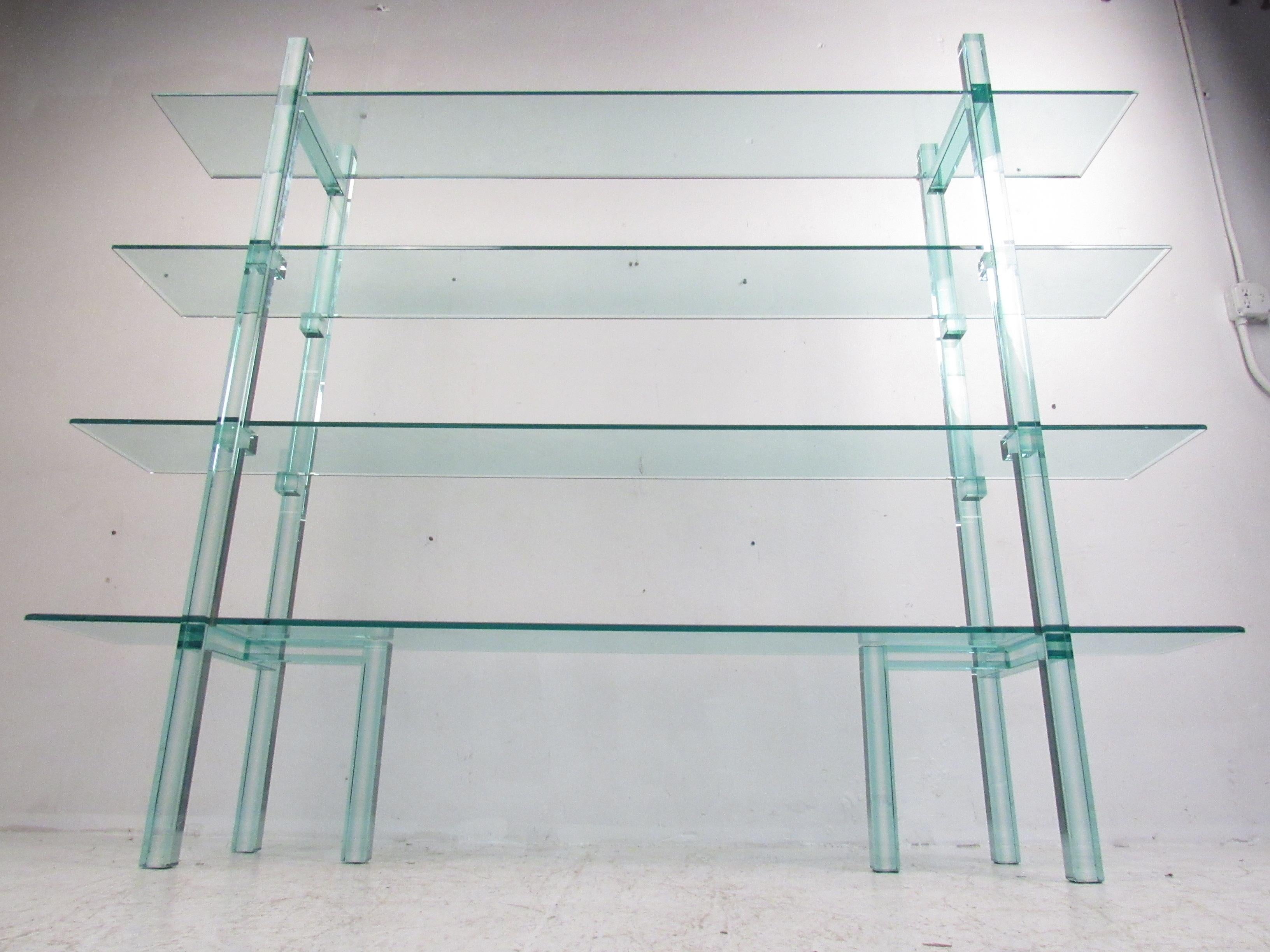 Dieses atemberaubende, moderne Bücherregal ist komplett aus Glas gefertigt und besticht durch seine blau-grüne Tönung, die durch das dicke, abgeschrägte Glas entsteht. Schlankes und ungewöhnliches Design mit zwei seitlichen Stützen auf