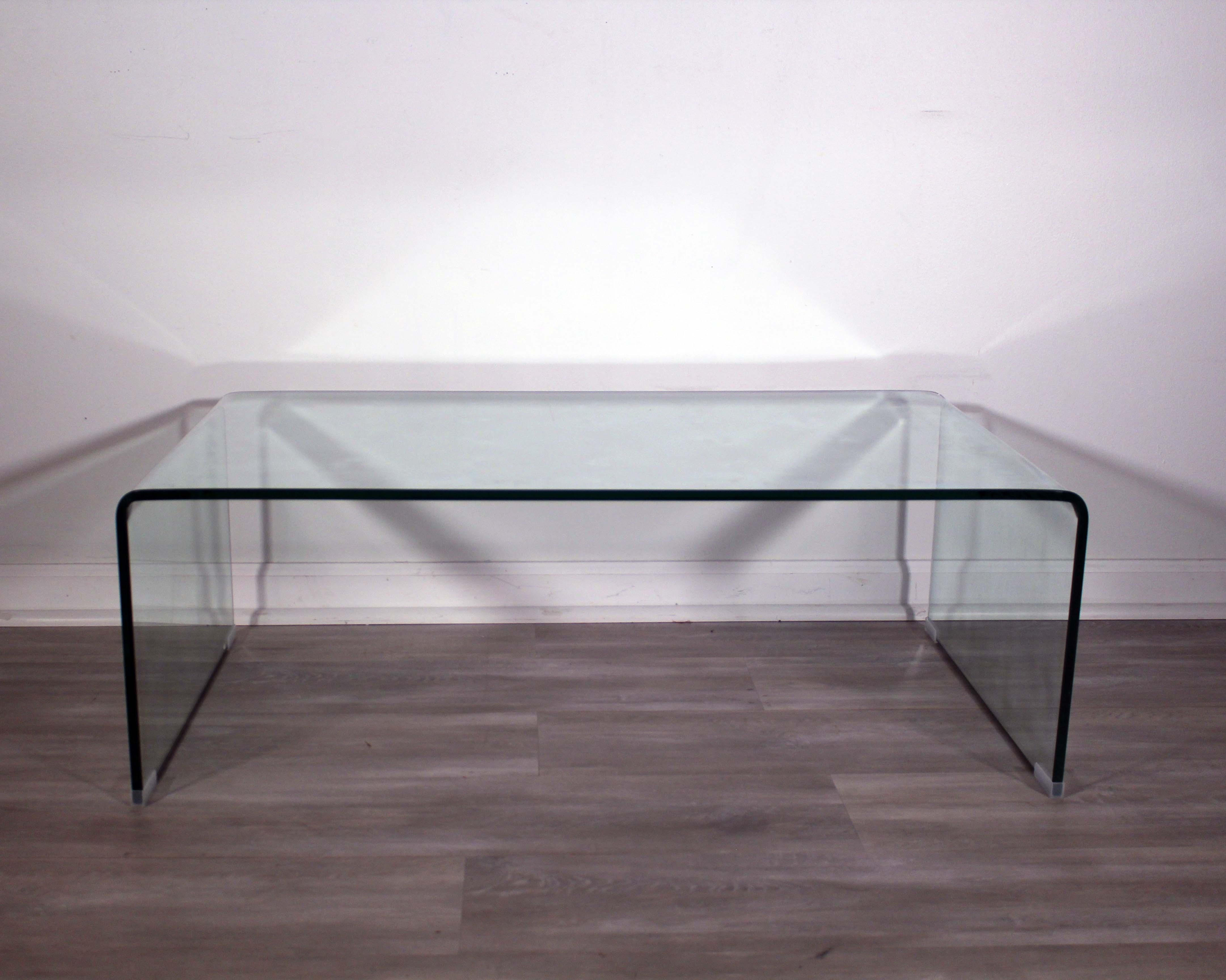 This exquisite glass waterfall coffee table will be the perfect centerpiece for your living room. Crafted from clear glass, its sleek design makes it a modern and contemporary statement piece. The table has a unique waterfall effect, with a curved