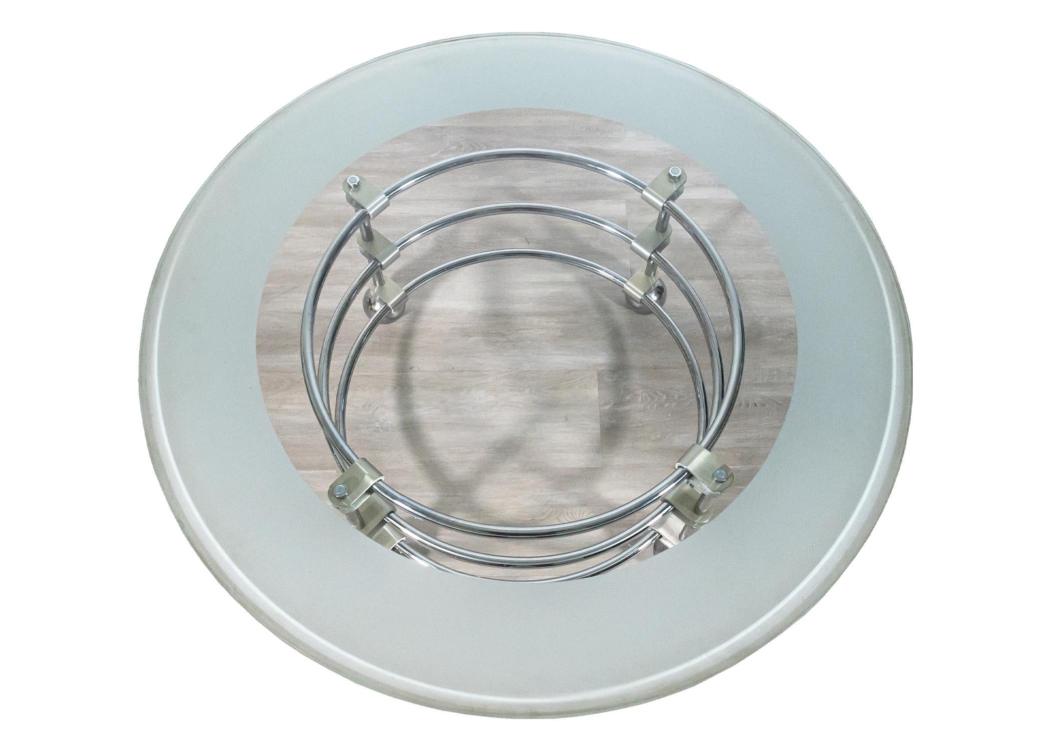 A Jay Spectre chrome and glass coffee table for century. This is a marvelous post-modern coffee table. This piece features a wonderful circular glass tabletop with a blue smoked glass border. The base of the table has a futuristic chrome