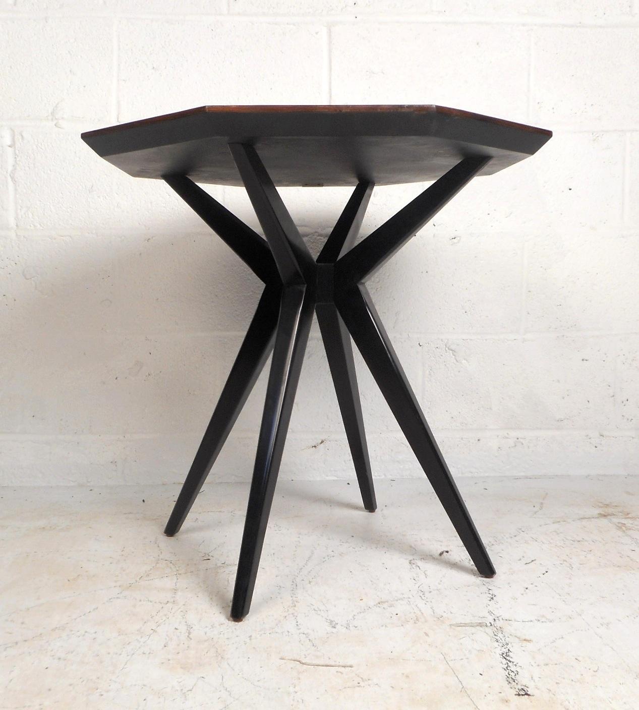 This stunning end table mixes contemporary style with classic sensibilities to produce a unique allure. The table has a rosewood finish and a starburst pattern on top. Beneath the tabletop are splayed onyx legs in a sleek design. This Kate Spade end
