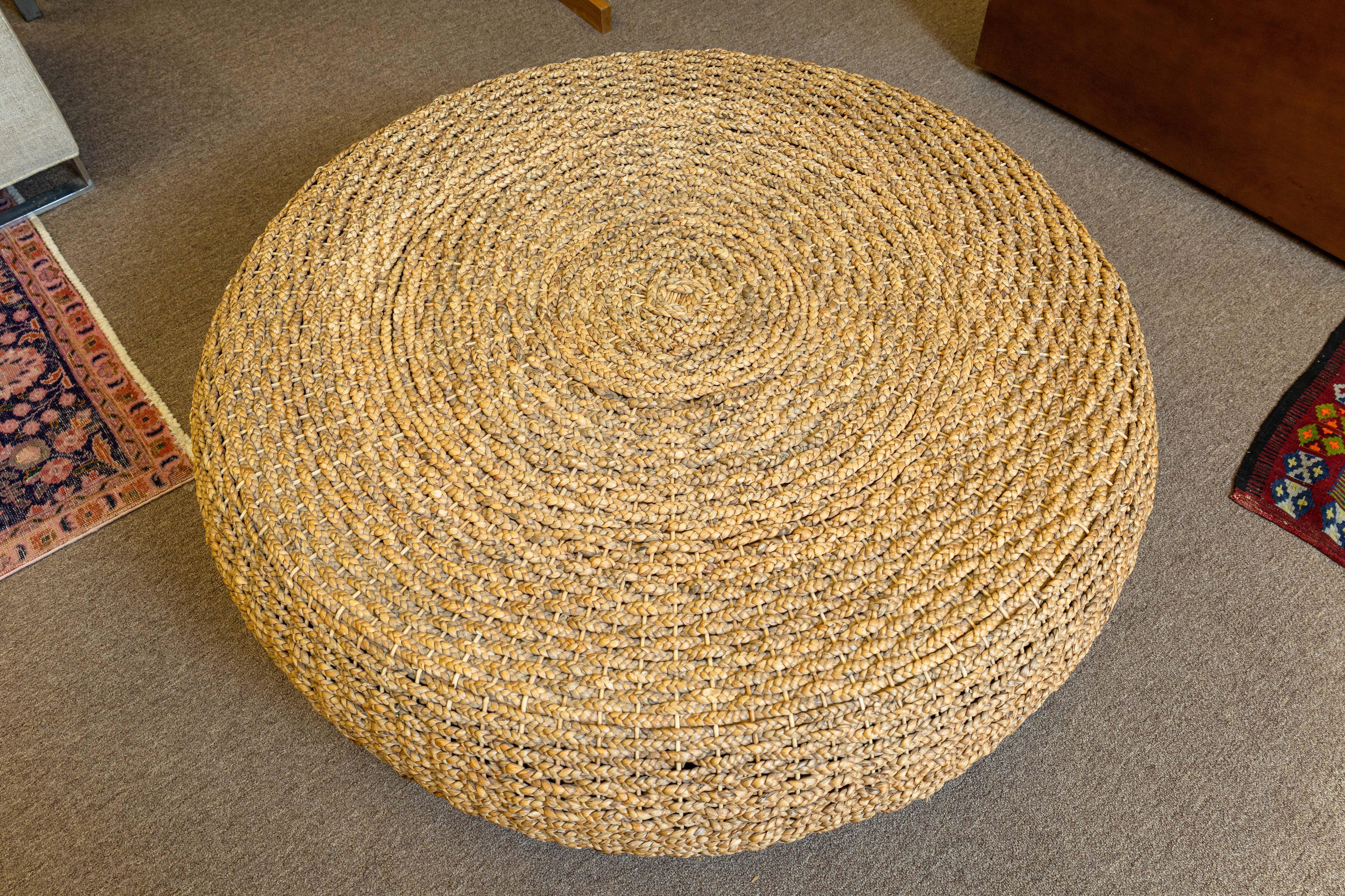 Un ottoman ou une table basse en rotin rond surdimensionné contemporain. Cette jolie pièce moderne est construite avec un cadre en bois robuste, et décorée d'une enveloppe en rotin tressé. Le rotin présente un motif circulaire en spirale qui donne