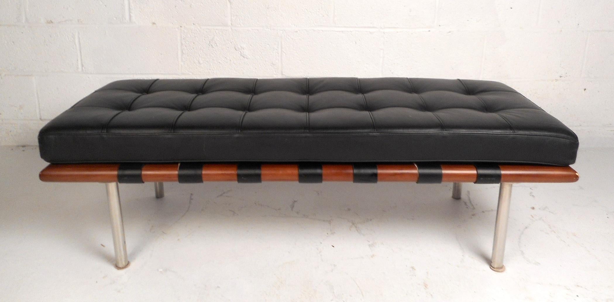 This lovely contemporary leather bench has a thick and soft tufted cushion. The comfortable bench cushion is fastened to the sleek teak frame with leather straps to prevent it from sliding off. The entire bench sits atop cylindrical chrome legs.