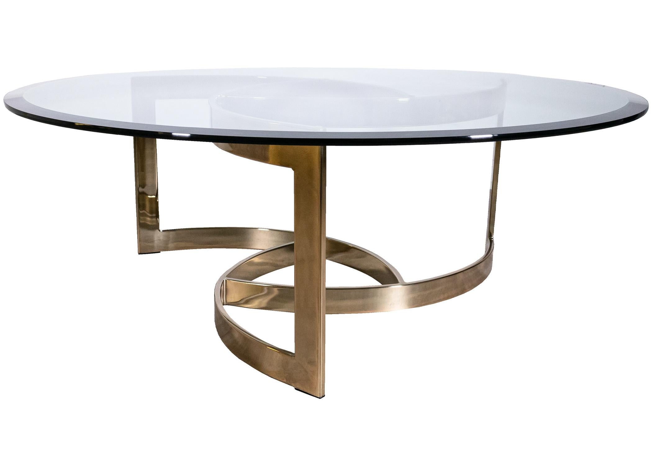 A Leon Rosen for Pace, 80's round sculptural brass & glass coffee table. A beautiful sculptural piece to match any 80's lover's home. This piece features a wonderful glass top with an angled edge, and a stunning spiral brass frame. The glass is in