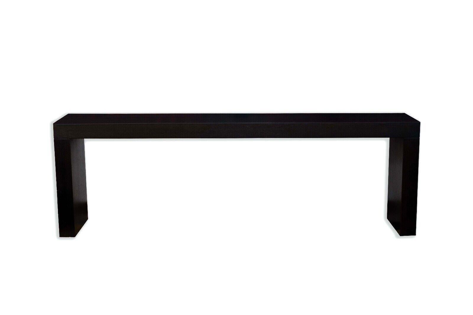 This is a contemporary modern console table, characterized by its long, dark, rectangular shape and clean, sharp lines. Crafted from wood, the table's rich dark finish exudes elegance and modernity, making it a versatile addition to any space. Its