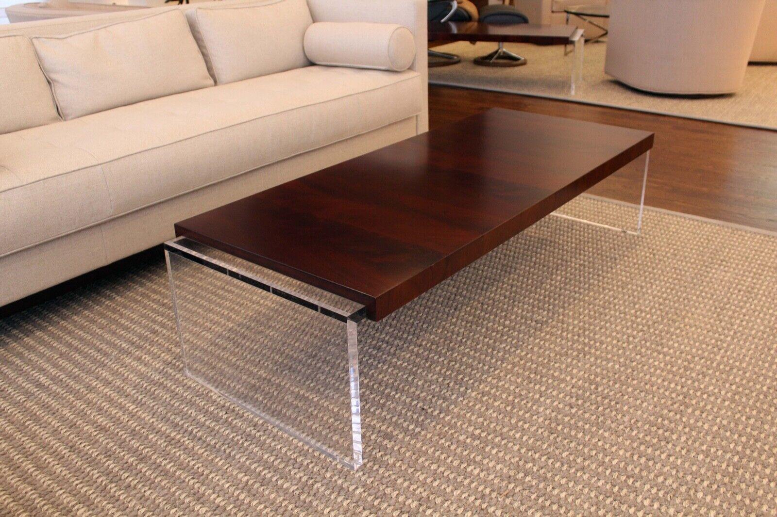 This lucite and walnut coffee table by Bolier for Decca is the perfect combination of modern and industrial design. This eye-catching piece features an acrylic base with a walnut top. The combination of two natural materials creates a unique and
