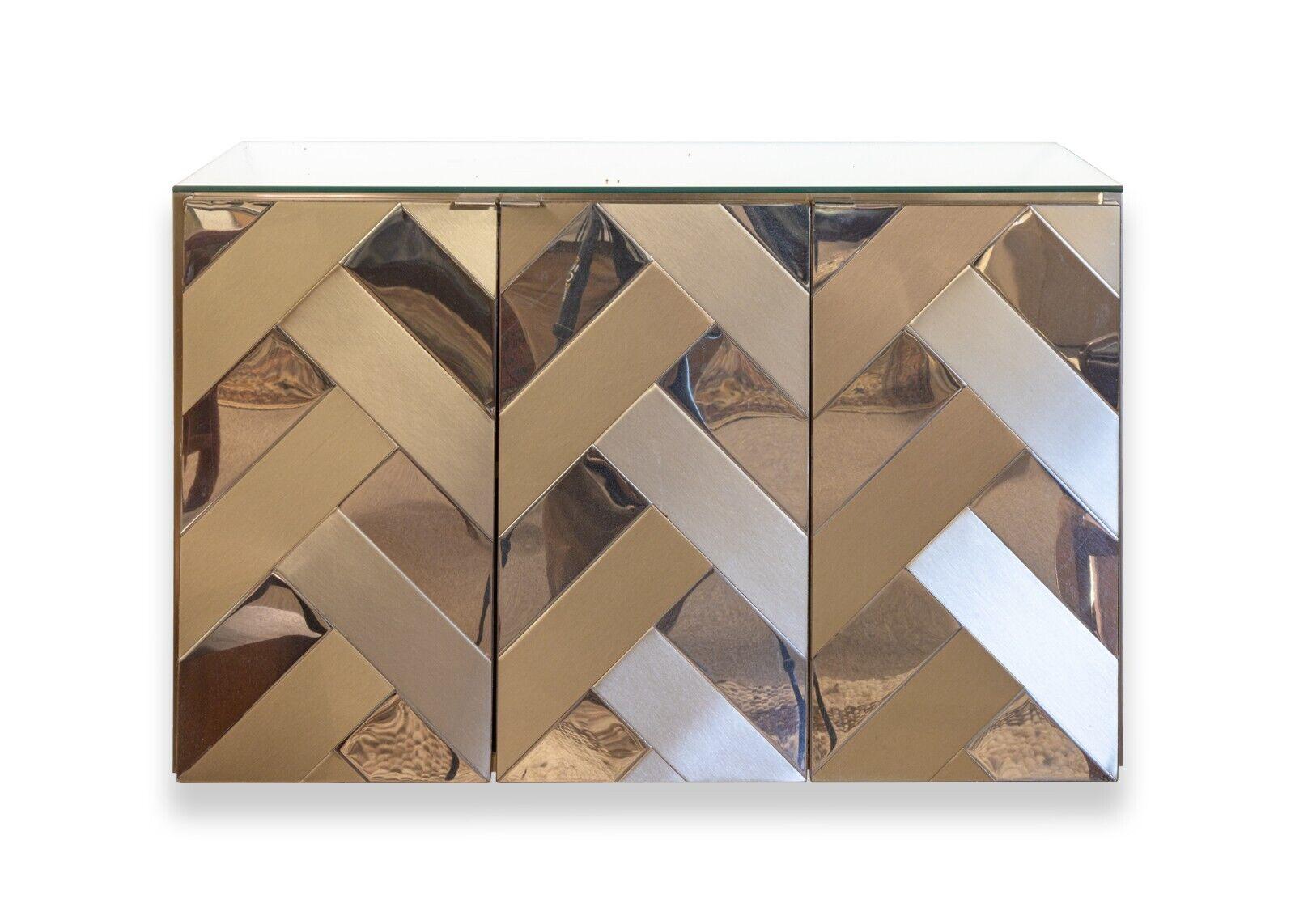 A contemporary modern pair of Ello chevron mirrored wall mounted cabinets. A stunning set of floating wall cabinets from Ello furniture. This pair of wall cabinets feature a clean glass top, 3 doors each, and adjustable shelving within each cabinet.
