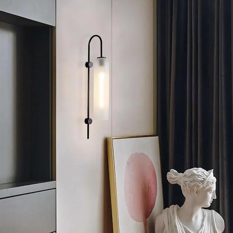 Contemporary modern black metal and glass wall sconce composed of a long frosted white glass lampshade and curved metal lamp body. Plug in light fixture with switch on cord.
Dimensions: 30.8”H x 7.9”W 
Lampshade height: 15.7”, diameter: 3.9” canopy: