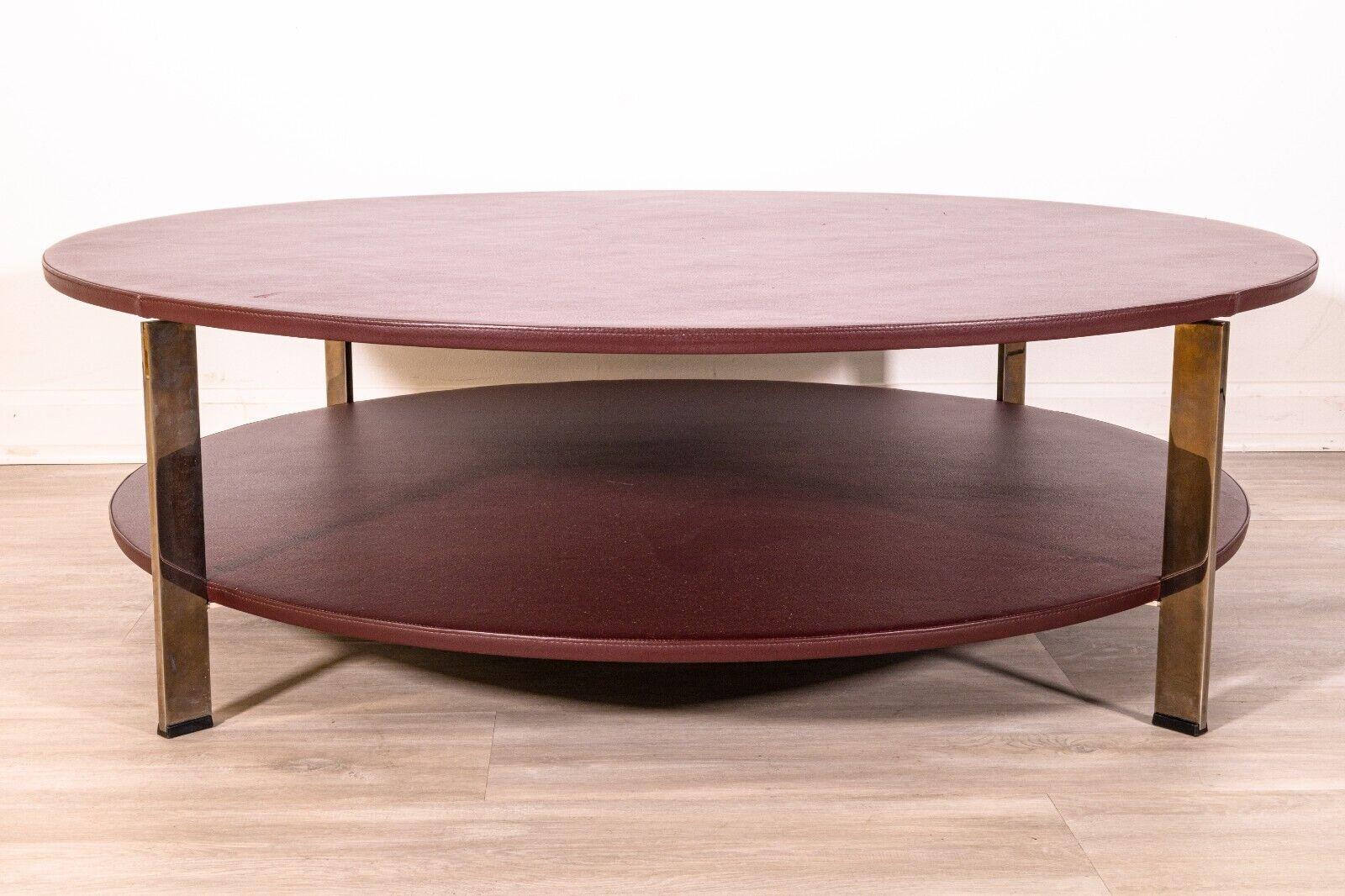 A Poltrona Frau Regolo leather wrapped two tier coffee table. This wonderful little coffee table is designed and manufactured by Italian furniture company Poltrona Frau. This table features a mix of wood and metal construction with a leather wrapped