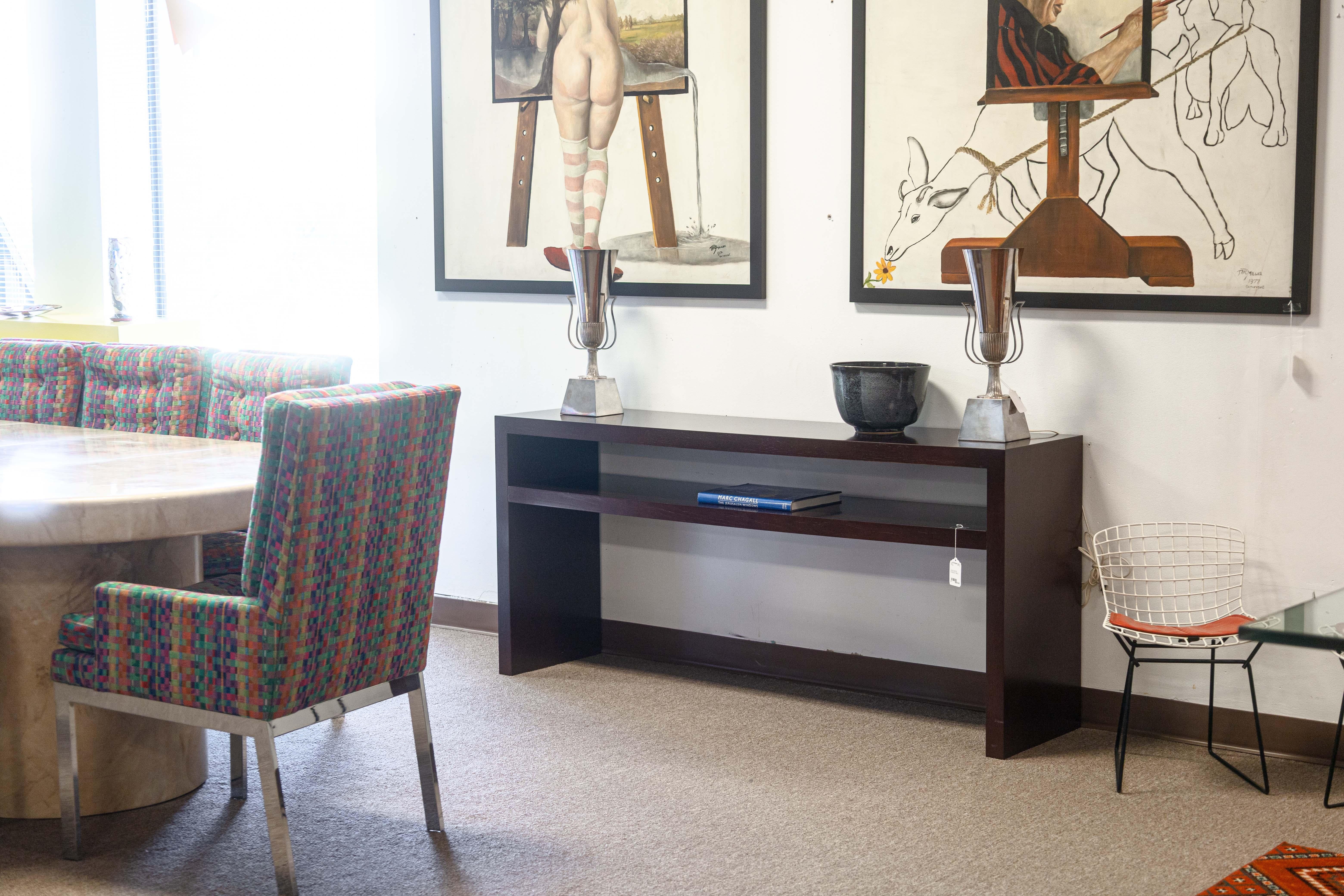 A contemporary modern rectangular wood console table. This beautiful modern table is constructed with a maroon colored wood with a semi-glossy finish. The long rectangular table also has a storage shelf on the underside of the tabletop. This piece