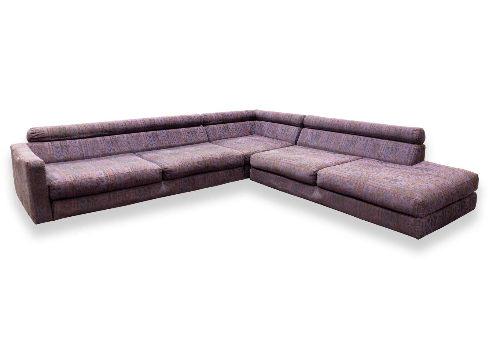A Roche Bobois purple two piece sofa sectional. This sofa sectional from luxury French furniture brand Roche Bobois features a two piece design. The left side a standard sofa, and the right corner a chaise style corner. This sofa is upholstered in a