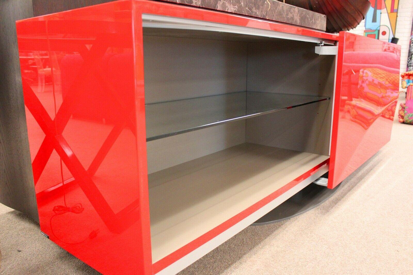 Italian design at its best, this sophisticated modern credenza in Red Lacquer by Roche Bobois can accommodate your media and storage needs.


The two horizontal sliding doors reveal a single glass shelf on one side, and a single shelf and drawer