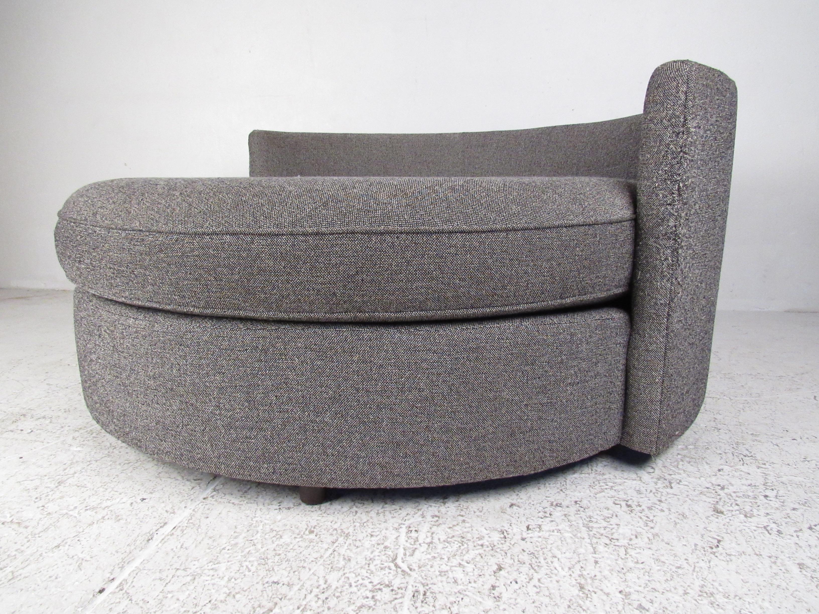 An unusual midcentury style design that ensures maximum comfort in any seating arrangement. A beautiful sofa with an overstuffed removable cushion and plush gray upholstery. By Mitchell Gold + Bob Williams. Please confirm item location (NY or NJ).