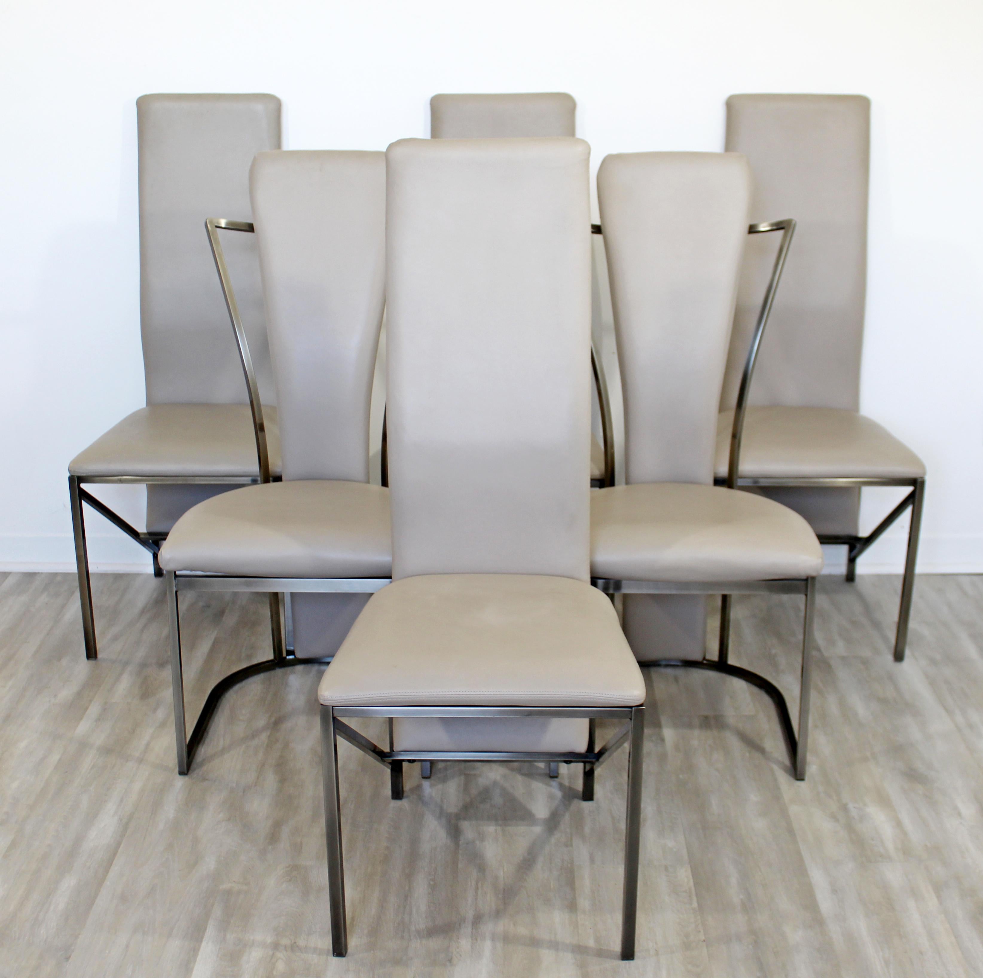 For your consideration is a spectacular set of six dining chairs, with leather seats on chrome bases, by The Design Institute of America, circa 1990. In excellent condition, with very slight wear to the upholstery. The dimensions are 18