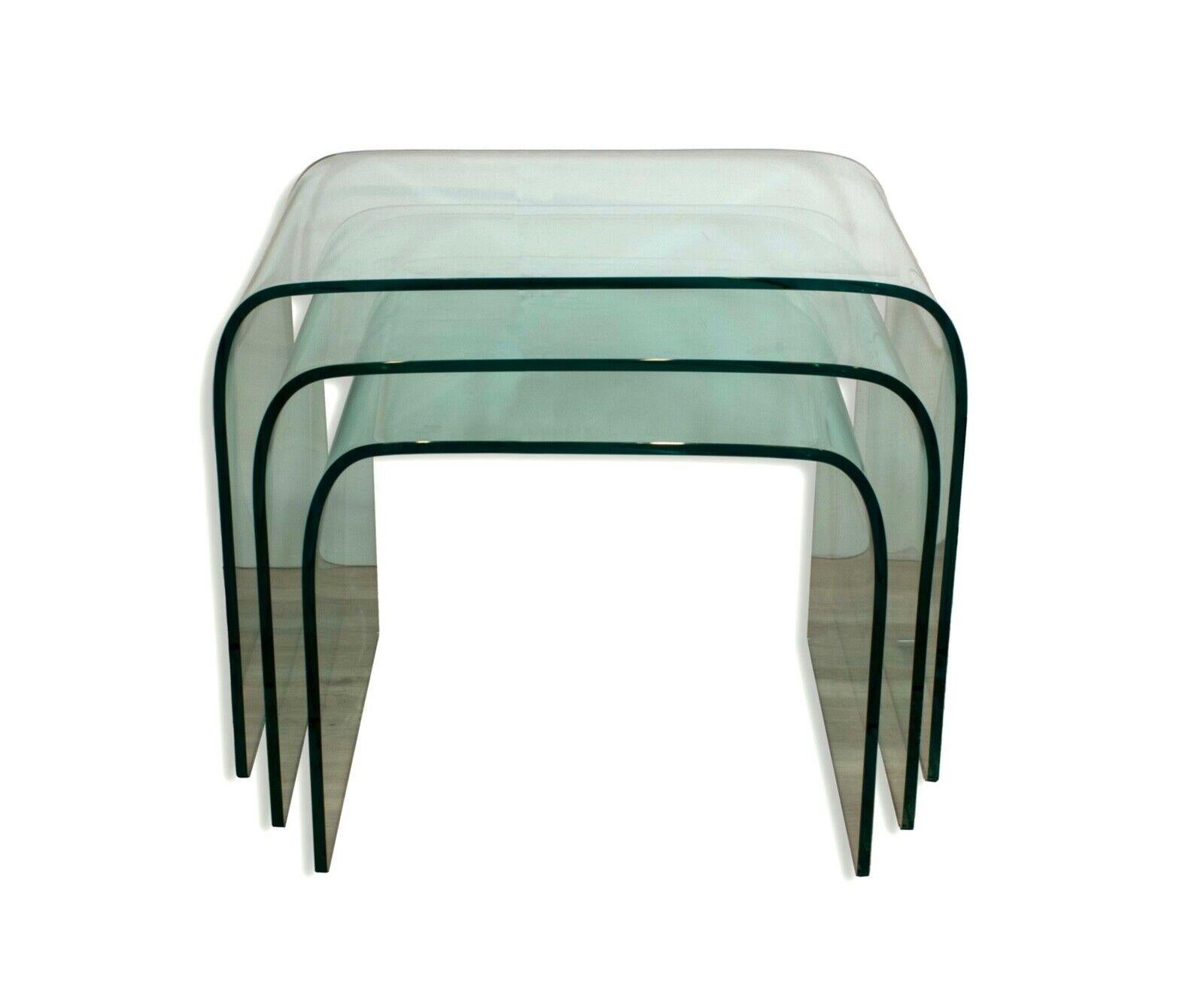 Elevate your living space with the exquisite Set of 3 Angelo Cortesi Fiam Waterfall Glass Nesting Tables. Designed by Angelo Cortesi, these tables seamlessly combine sleek modernity with timeless elegance. Crafted from premium quality glass, each