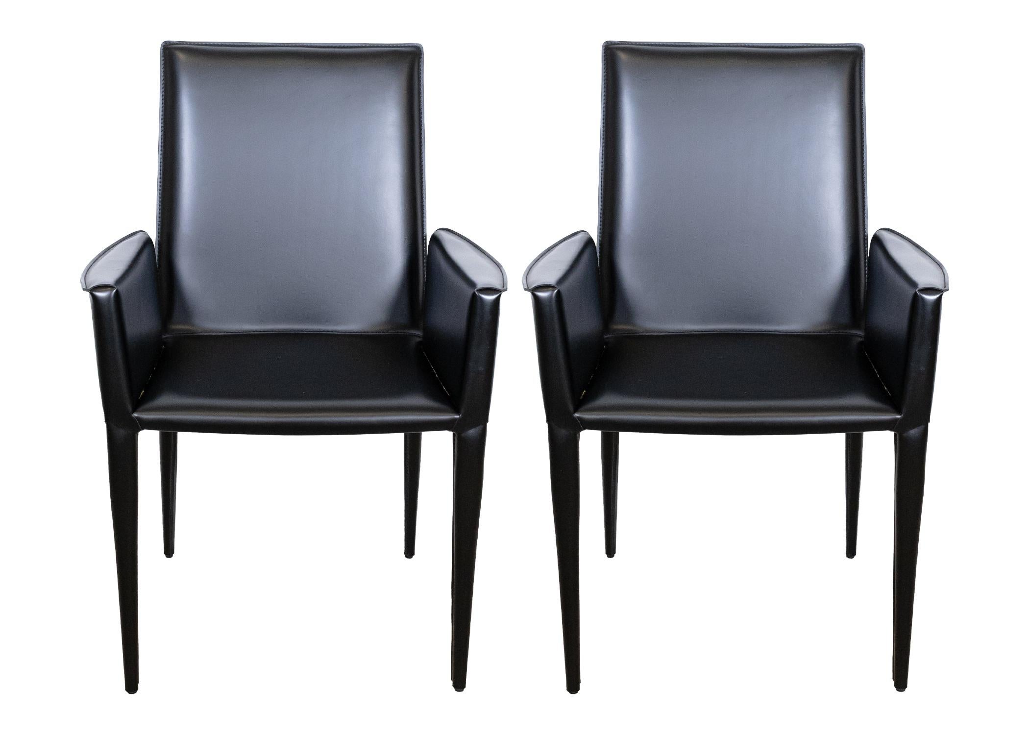 Set of 6 Frag Italian black leather dining chairs. This gorgeous set of black Italian leather chairs feature a two chair design. Two chairs for the end of the table have arms, and the four middle chairs are armless. All six of the chairs are in very